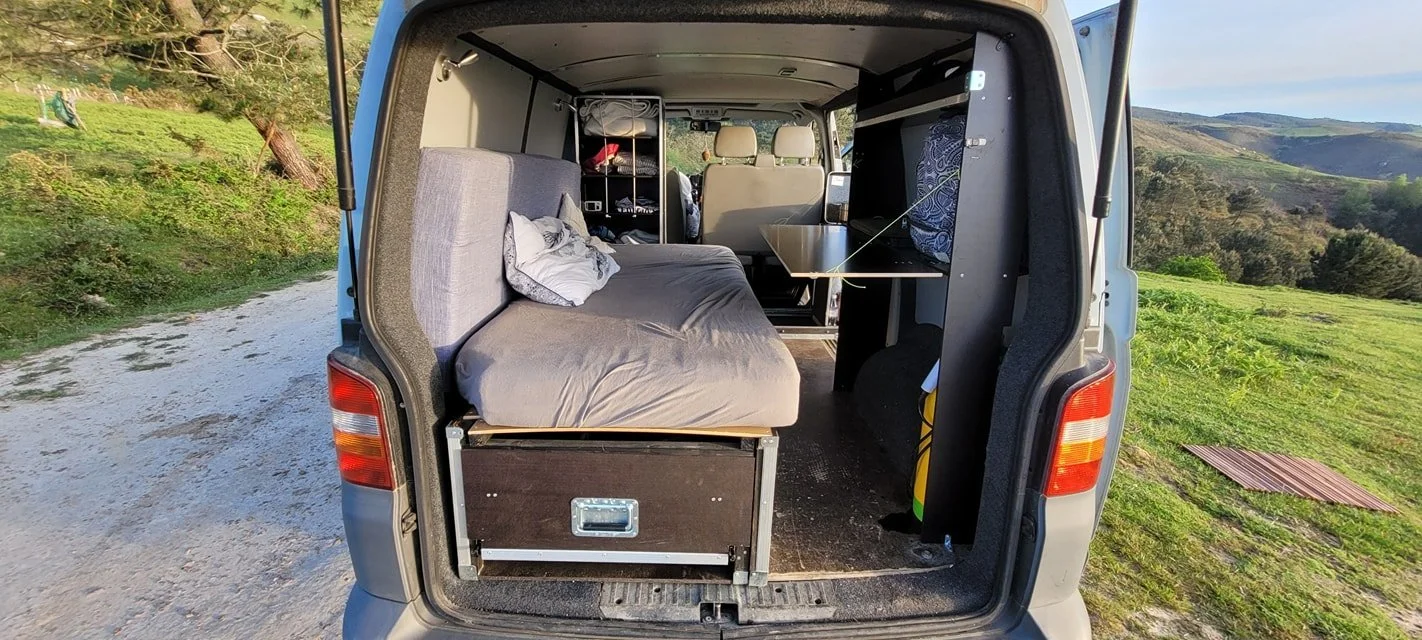 Intérieur d'une voiture aménagée en camping-car avec un lit,