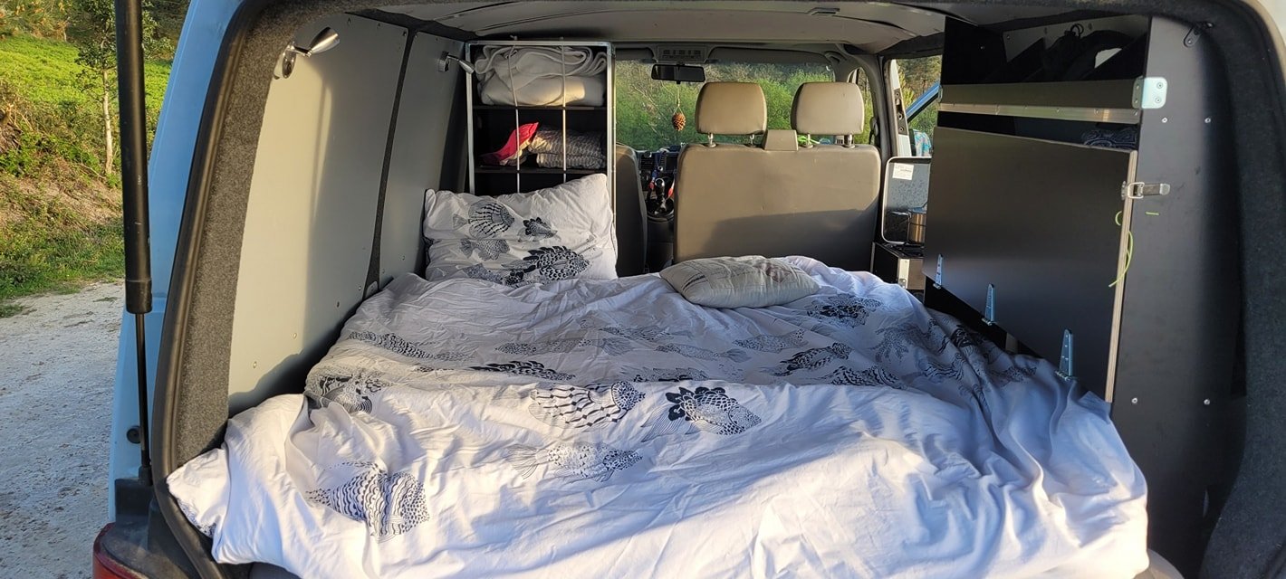 L'intérieur d'un véhicule aménagé en espace de couchage avec un lit.