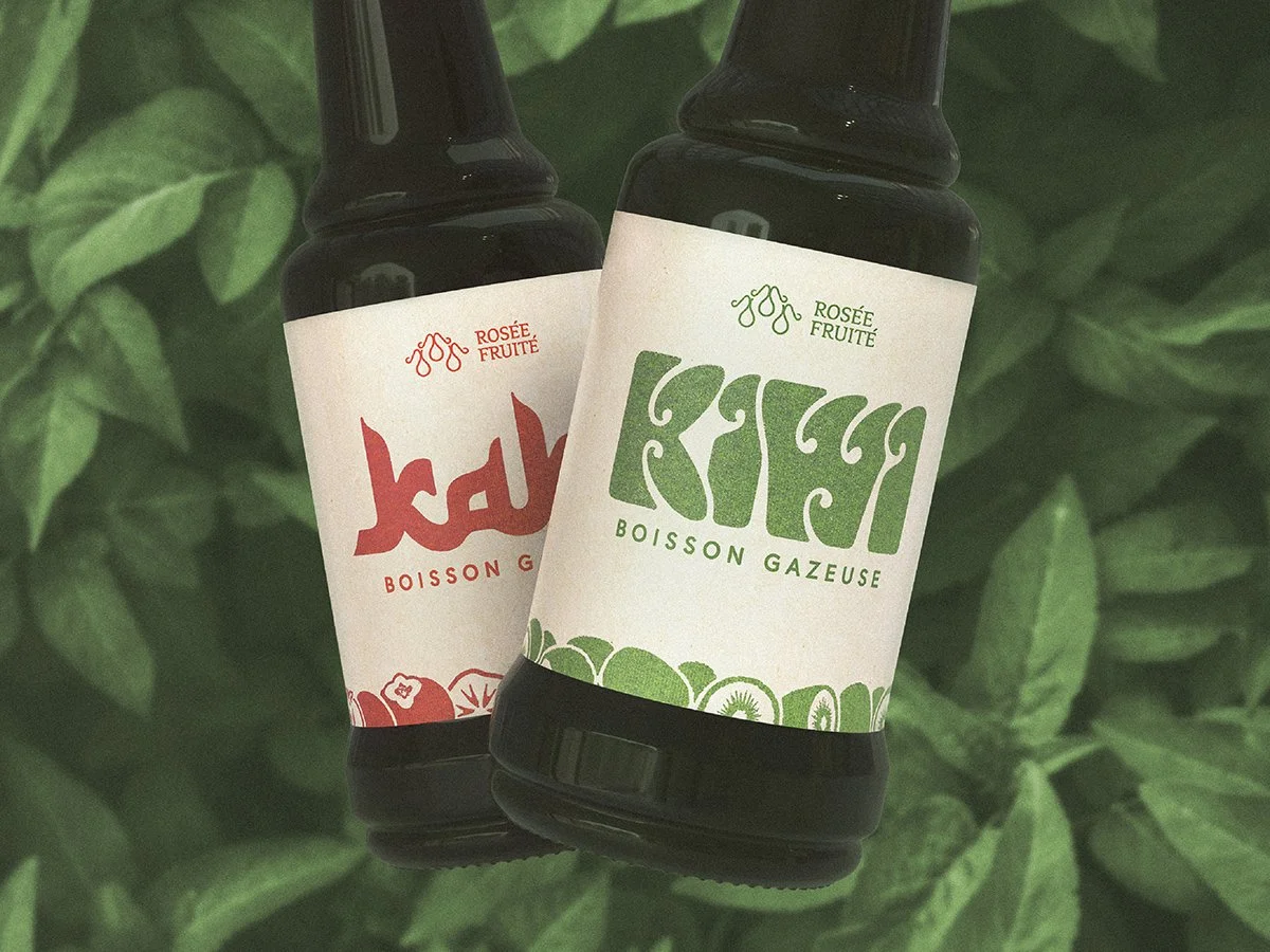 Two bottles of fruit-flavored beverages with labels featuring green and red text and graphics, set against a background of green leaves.