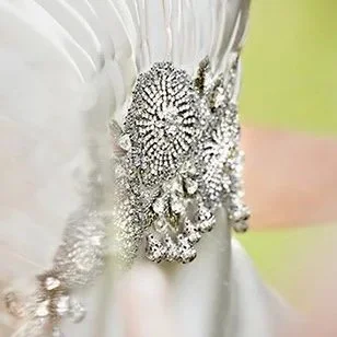 Close-up of a white fabric with intricate silver embellishments or embroidery.