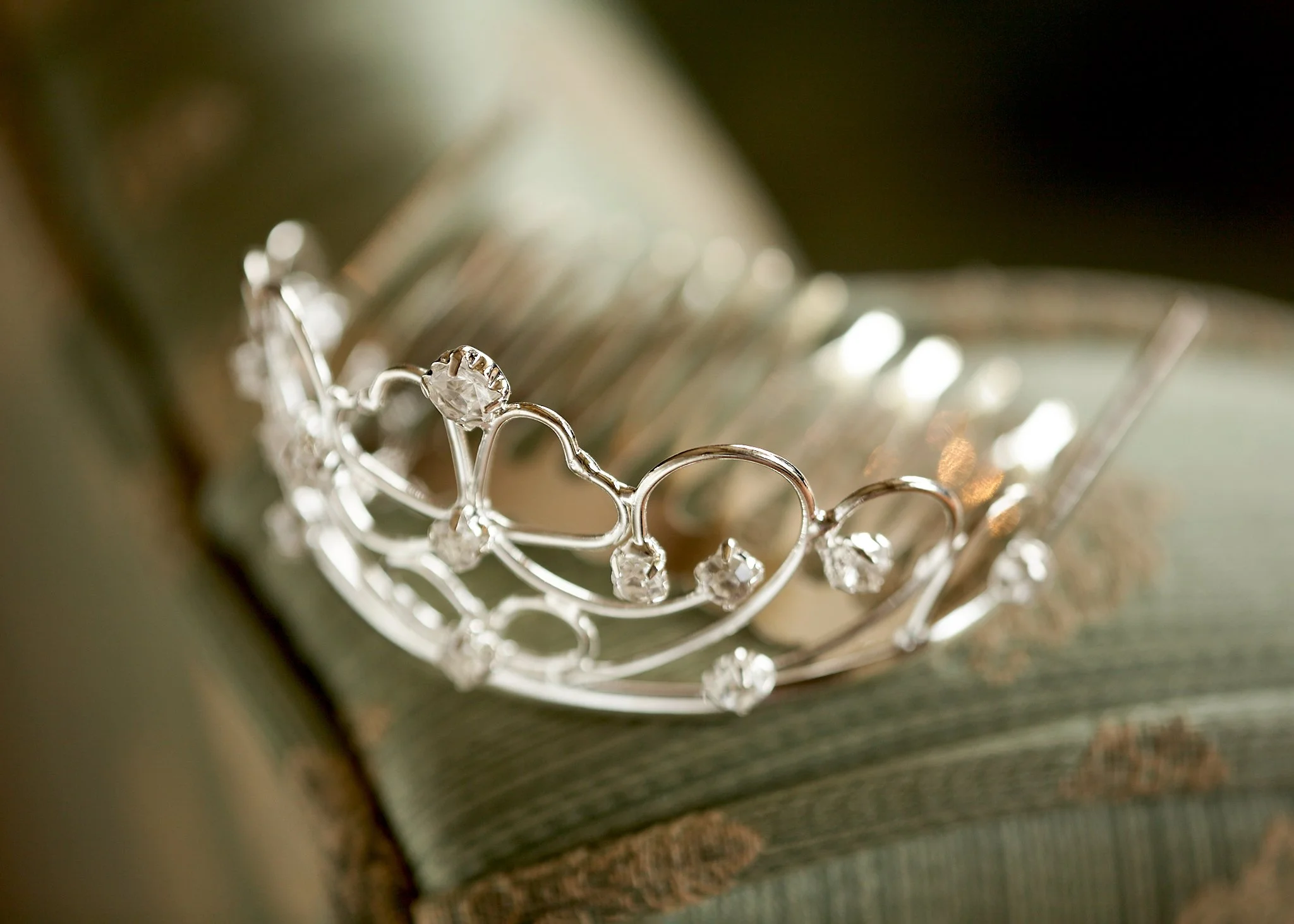 Close-up of silver jewelry with crystals on a jewelry display rack.