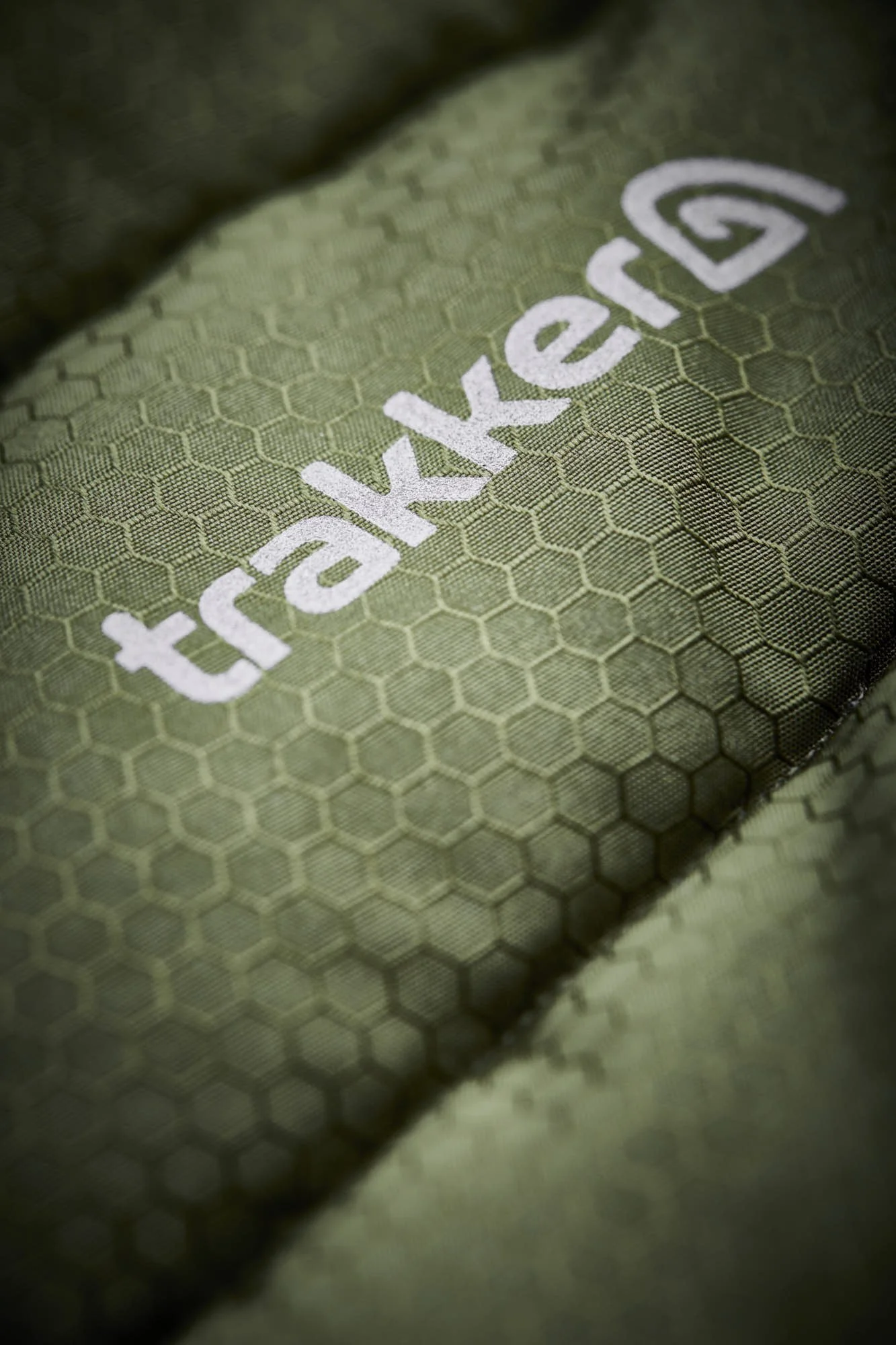 Close-up of a green fabric with a honeycomb pattern and the word 'hiking' embroidered in white.