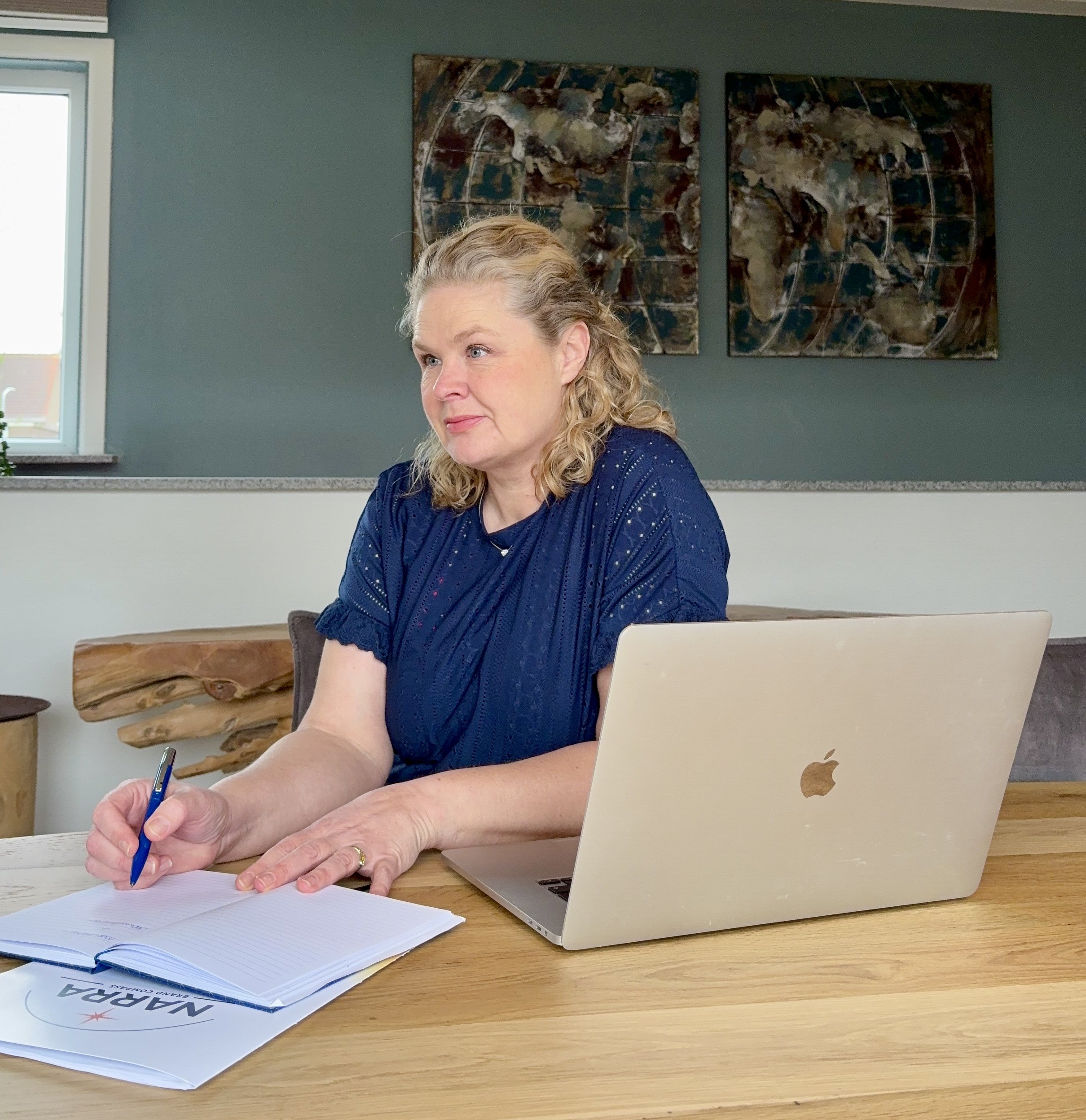 Joëla van Dantzig schrijft aantekeningen in een NARRA-notitieboek naast haar laptop.