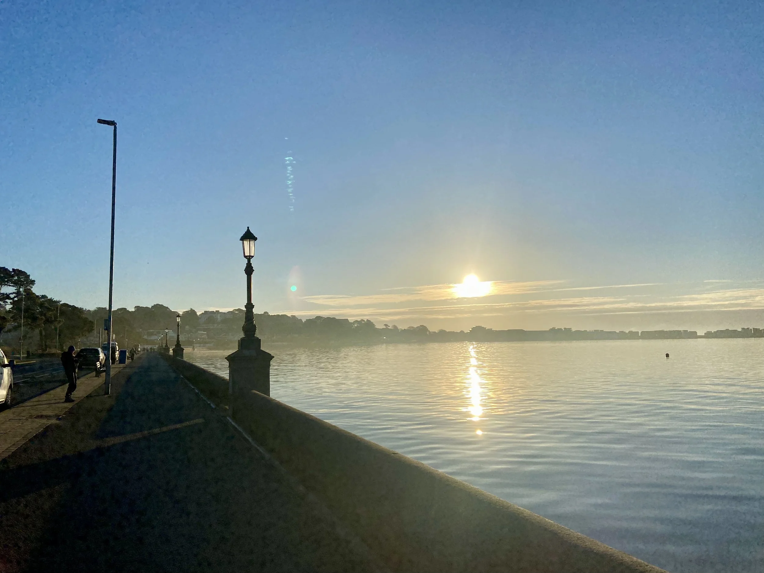 Setting sun at Poole Harbour with lantern in foreground