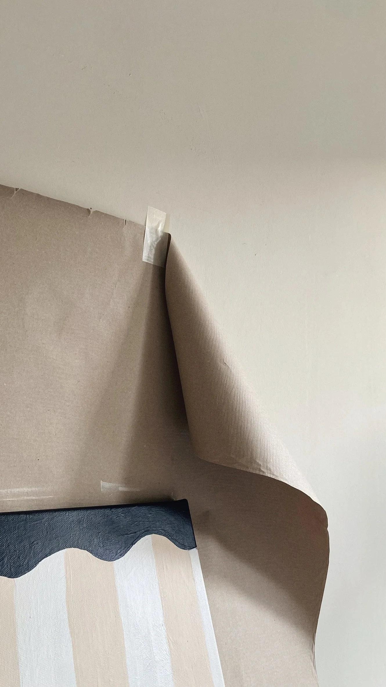 Ein abgerolltes Stück Papier auf einer glatten Oberfläche, mit einem schwarzen, gewellten Kunstwerk auf dem unteren Teil des Papiers