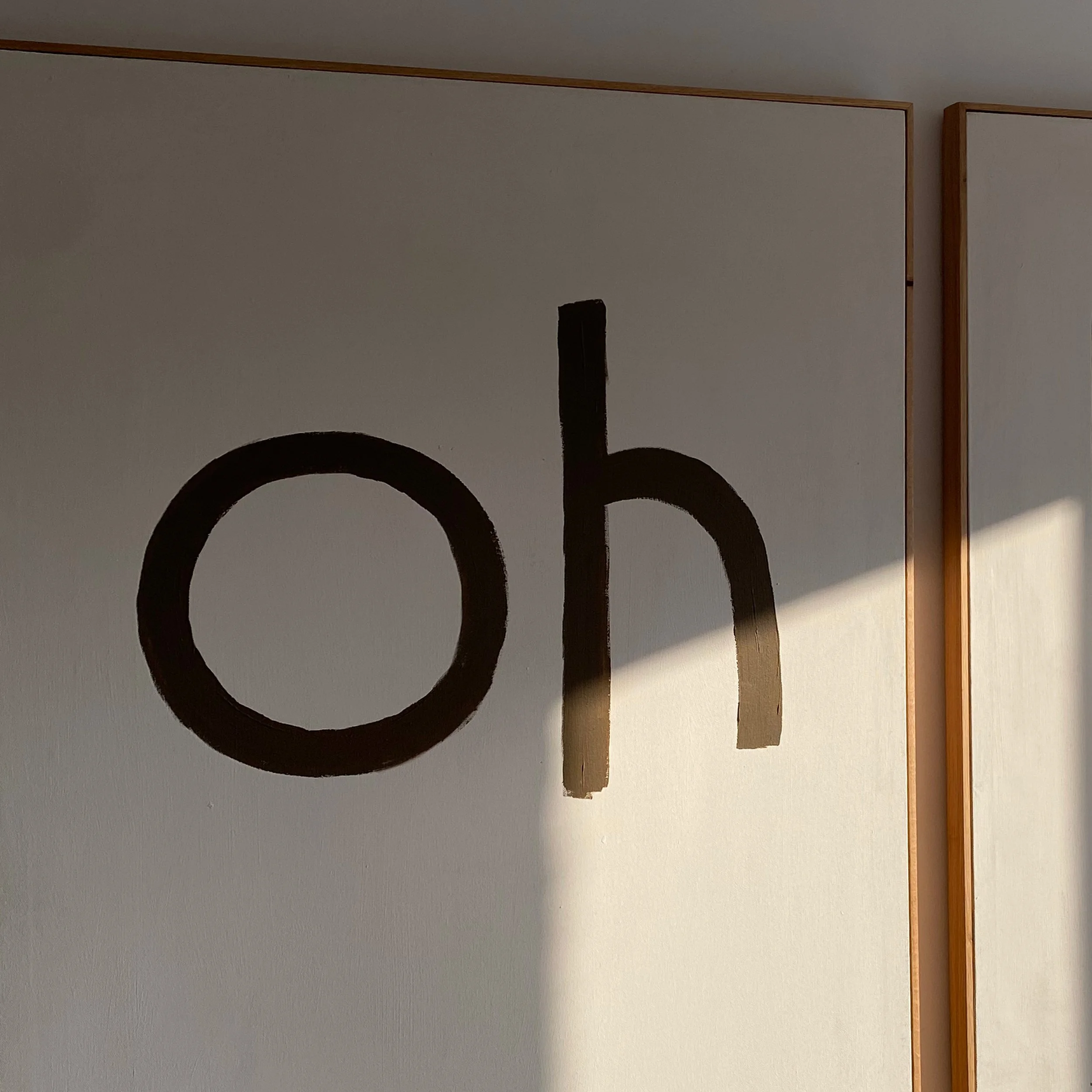Eine Wand mit braunem Schriftzug "oh hi", der teilweise sichtbar ist.