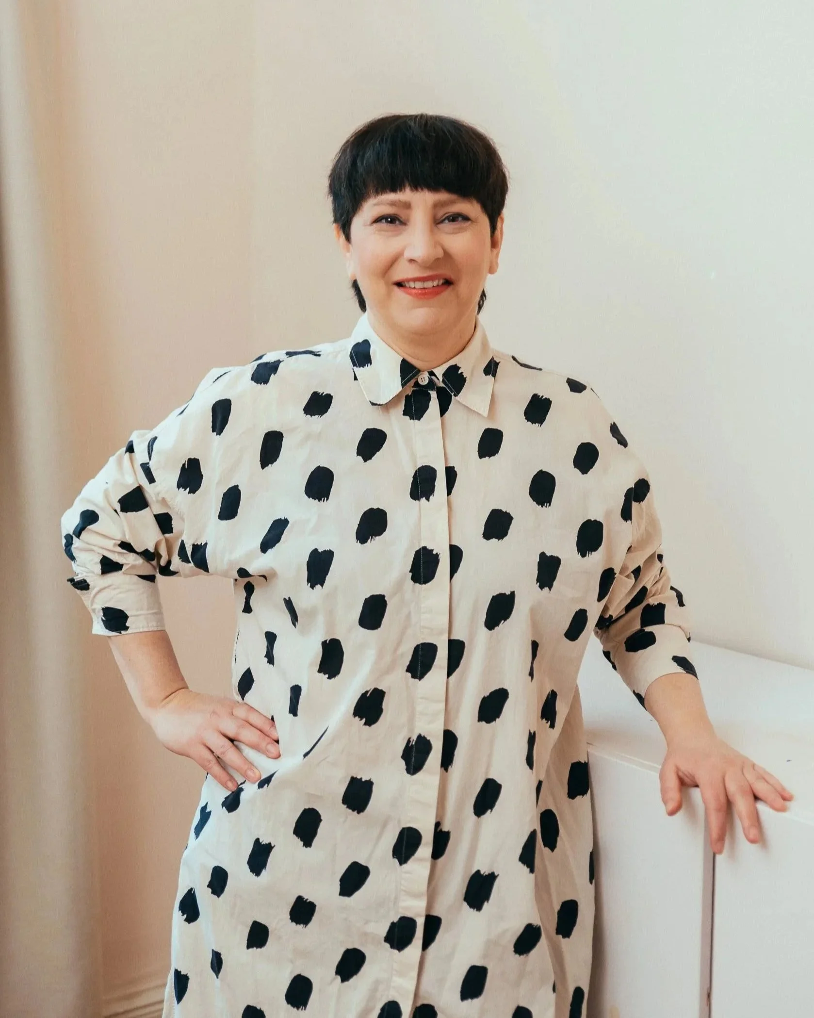 Ruth Biniwersi trägt ein weißes Hemd mit schwarzen Tupfen und hat kurze schwarze Haare.