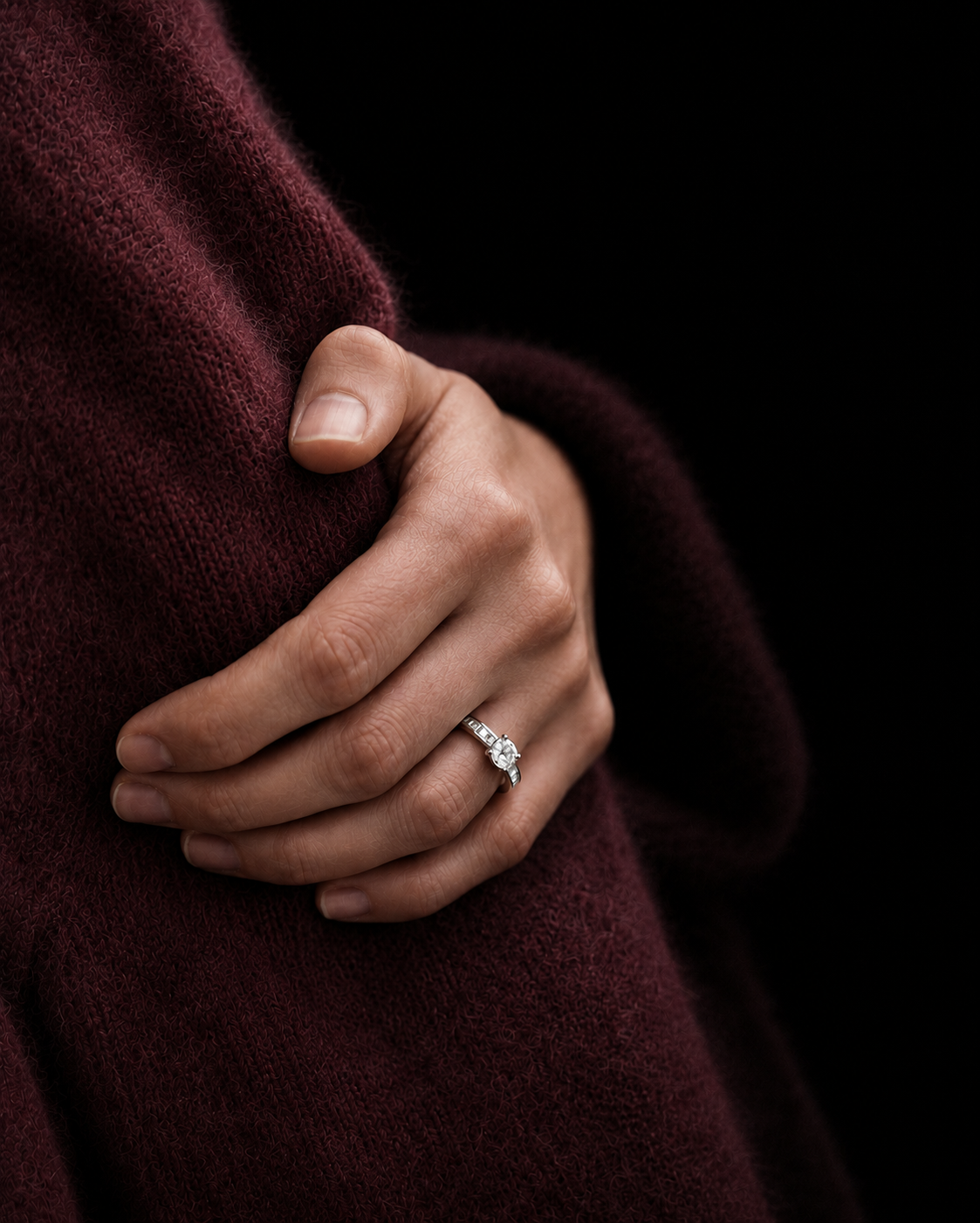 Hand wearing a timeless platinum diamond engagement ring with classic solitaire design with a channel set setting. The ring is timeless, classic and elegant. With refined proportions, handcrafted bespoke jewellery for everyday wear.
