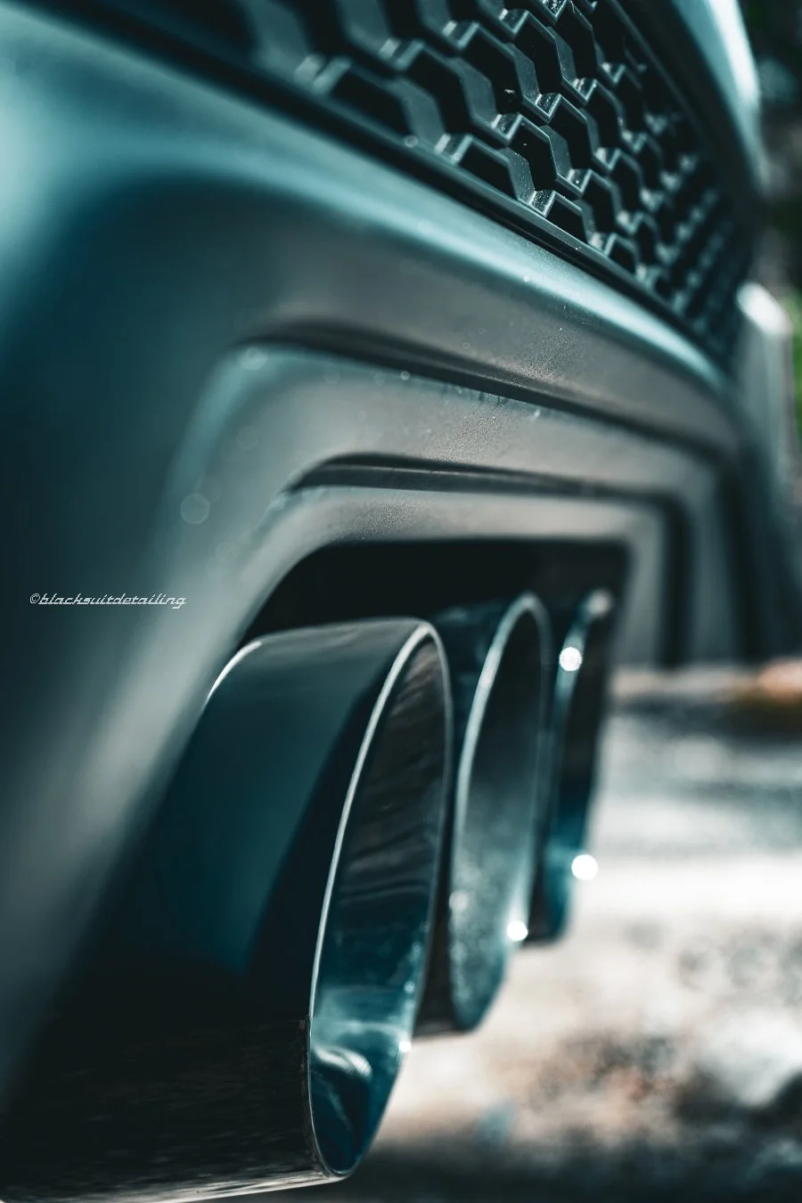 Close-up of the rear exhaust pipes and diffuser of a sports car.