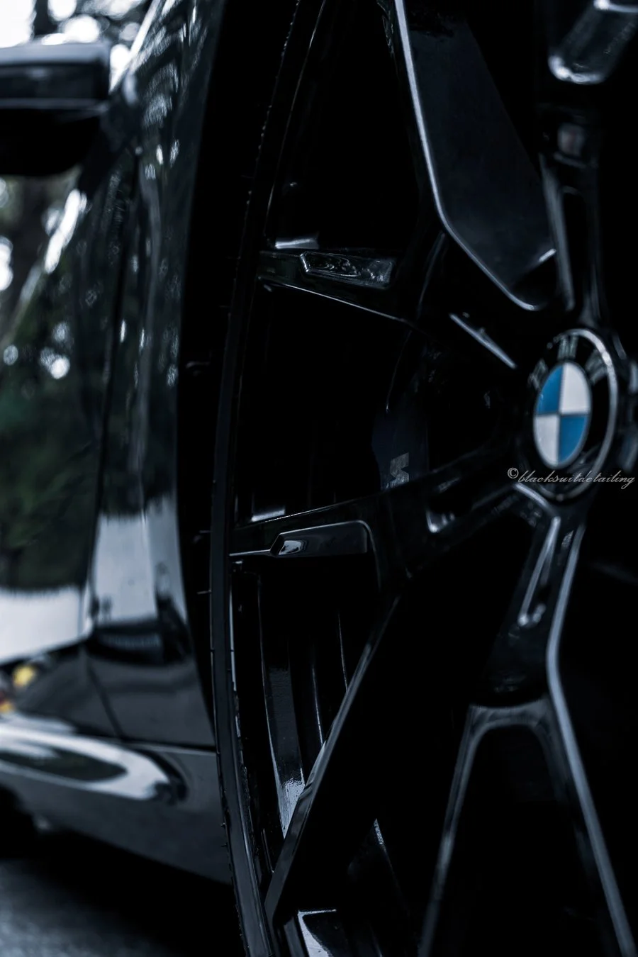 Close-up of a black BMW car's front grille with the BMW logo visible.