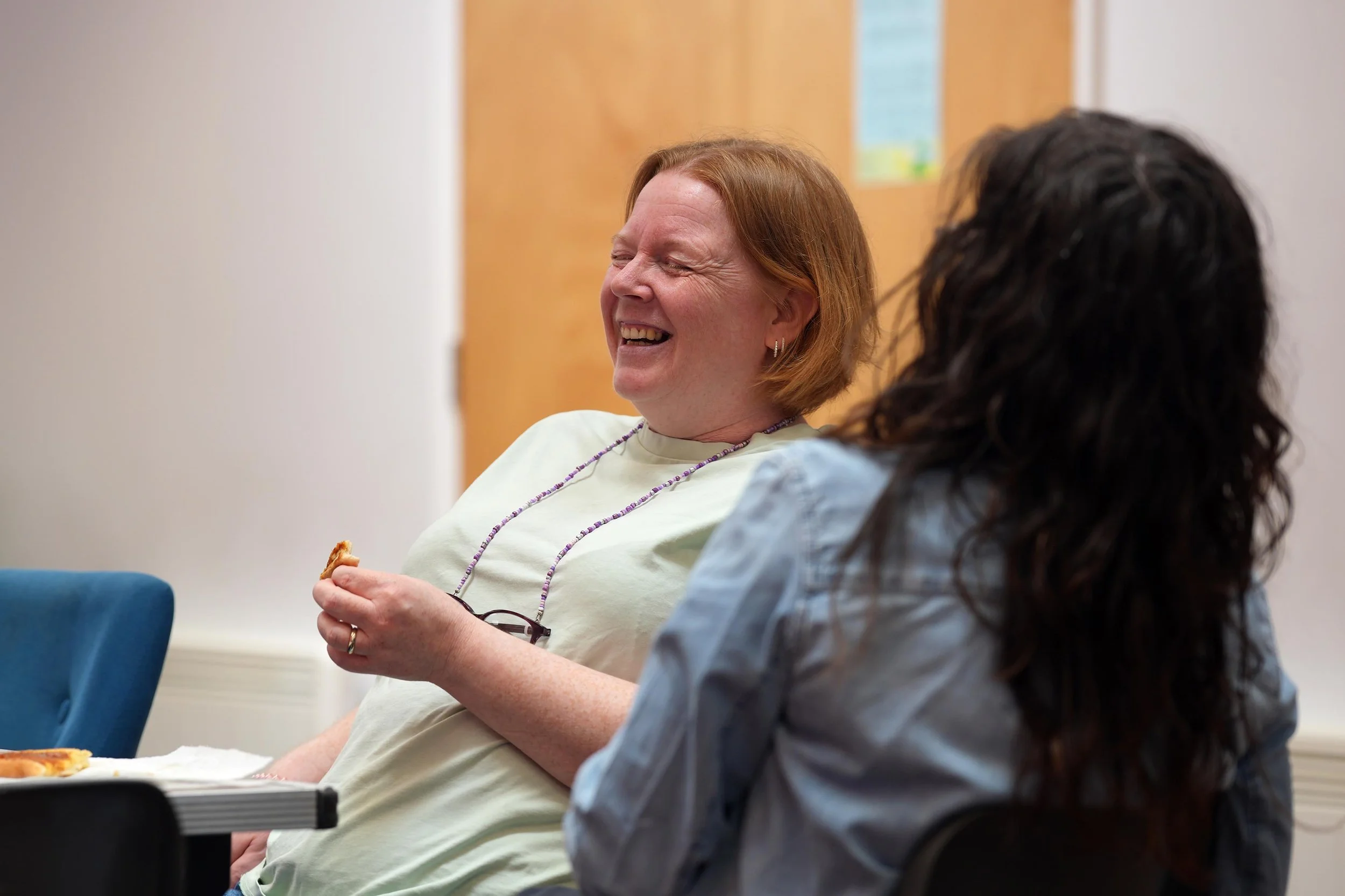Two women sitting and laughing together at The Net community group for women. #Grace #Community #TheNet
