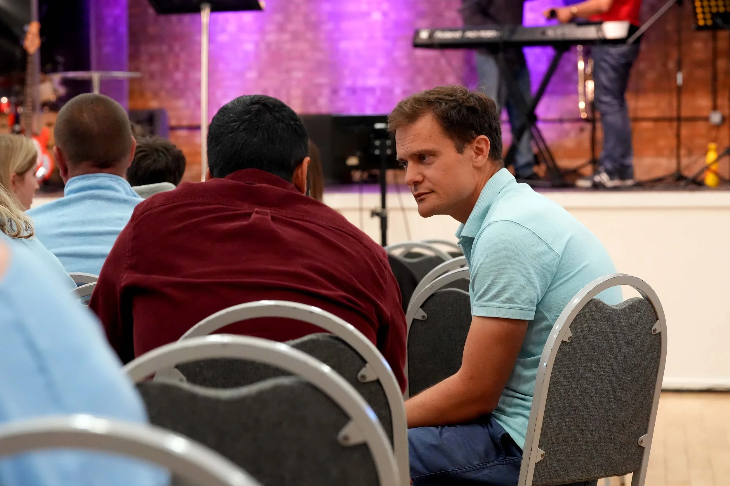 Two men talking and supporting one another after a church service at Grace