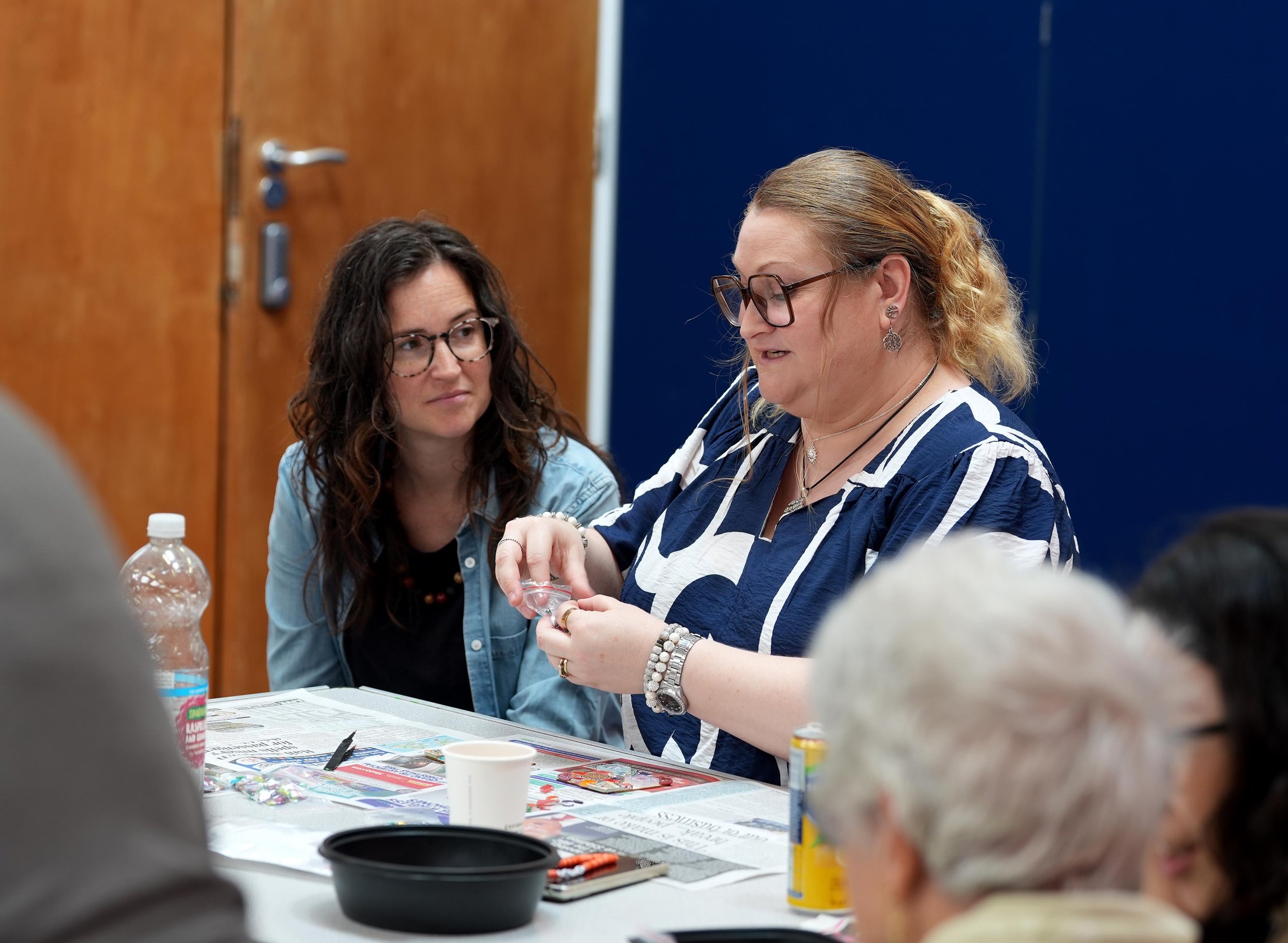 Two women sitting at a table engaged in conversation during The Net community group for women. #Grace #Community #TheNet