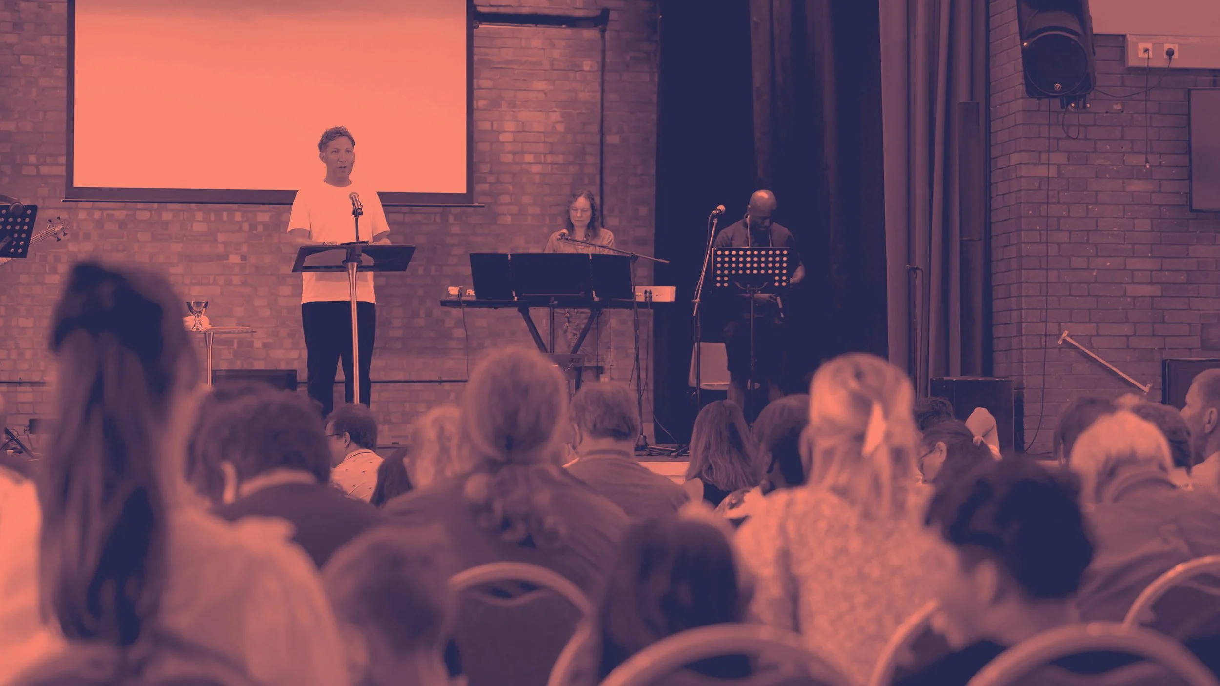 A man standing at a podium speaking to the congregation during our Sunday services. #Grace #Church #SundayServices