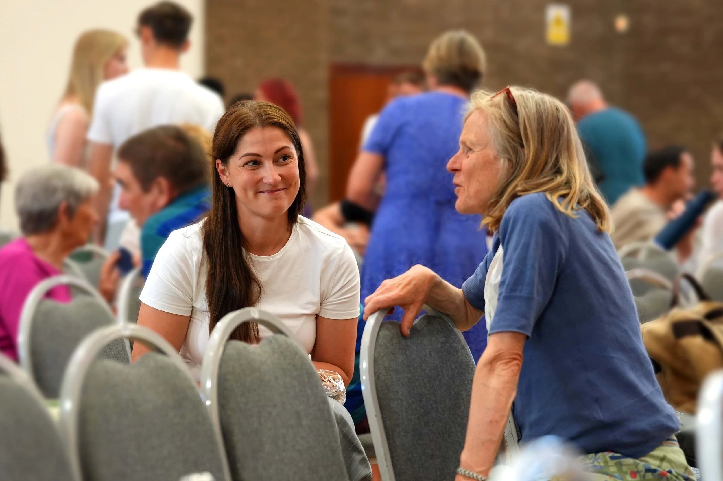 Two women sitting and engaging in conversation after a Sunday Service at Grace Community Church. #Church #Community #family