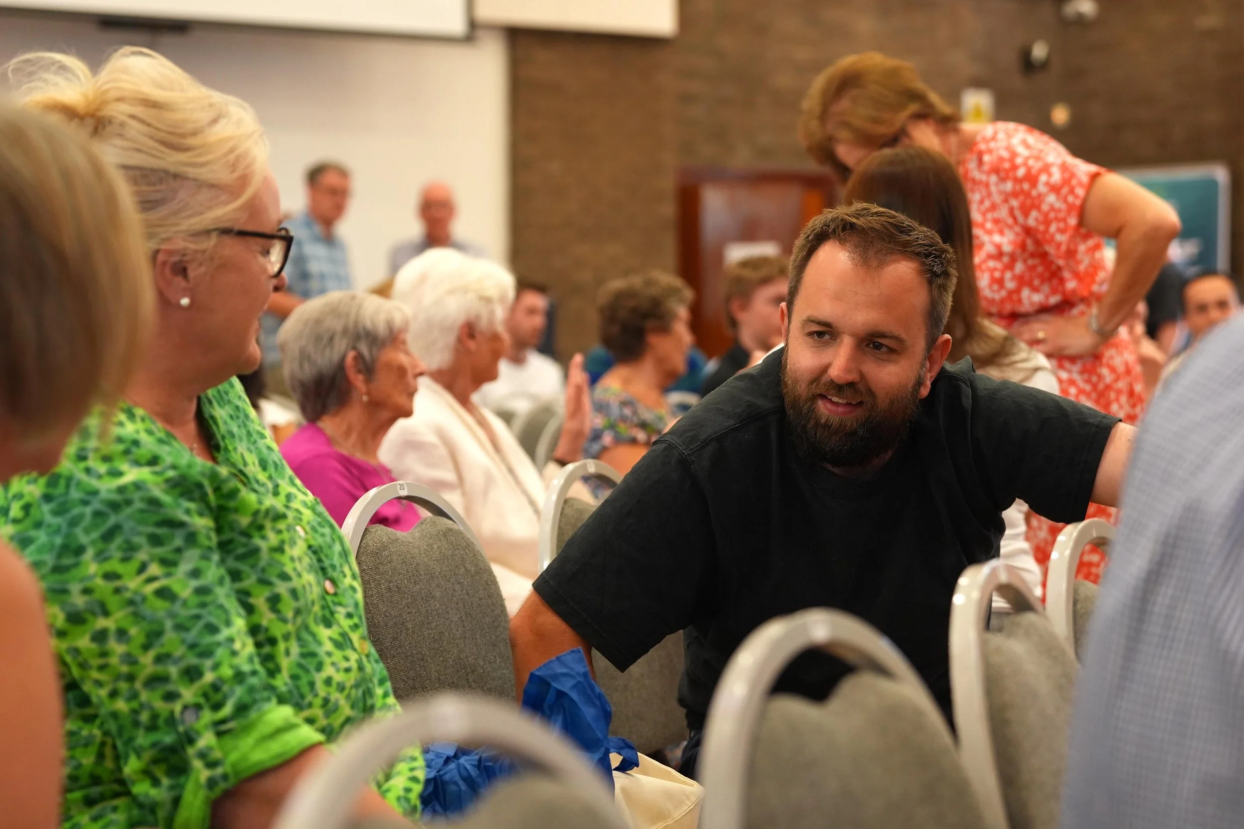 A group of people sitting and talking after a Sunday Service at Grace Community Church, Bedford.