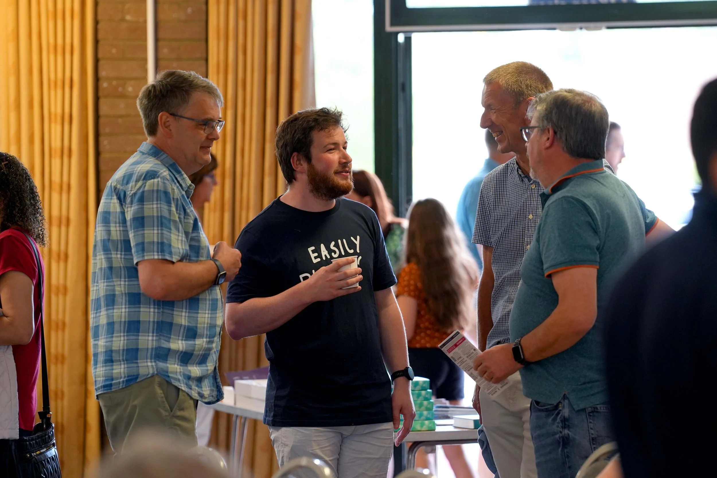 Group of people engaging in conversation at a Sunday Service at Grace Community Church, where refreshments are served after all our services #Community #Church #Bedford