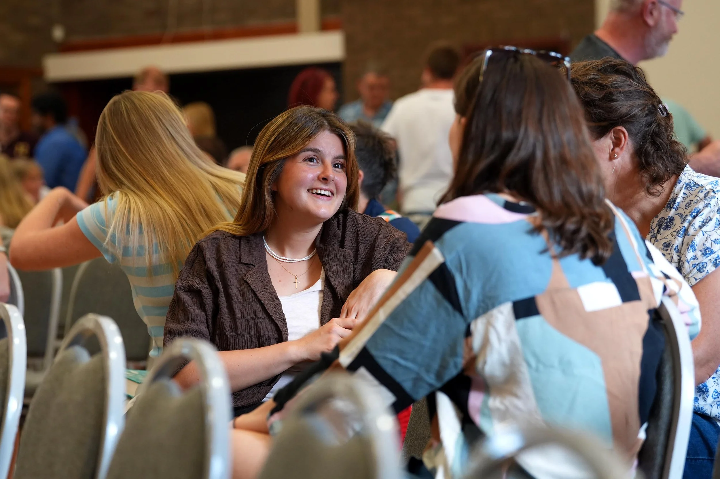 A smiling woman engaging in conversation after one of our Sunday Services. #Grace #Church #SundayServices