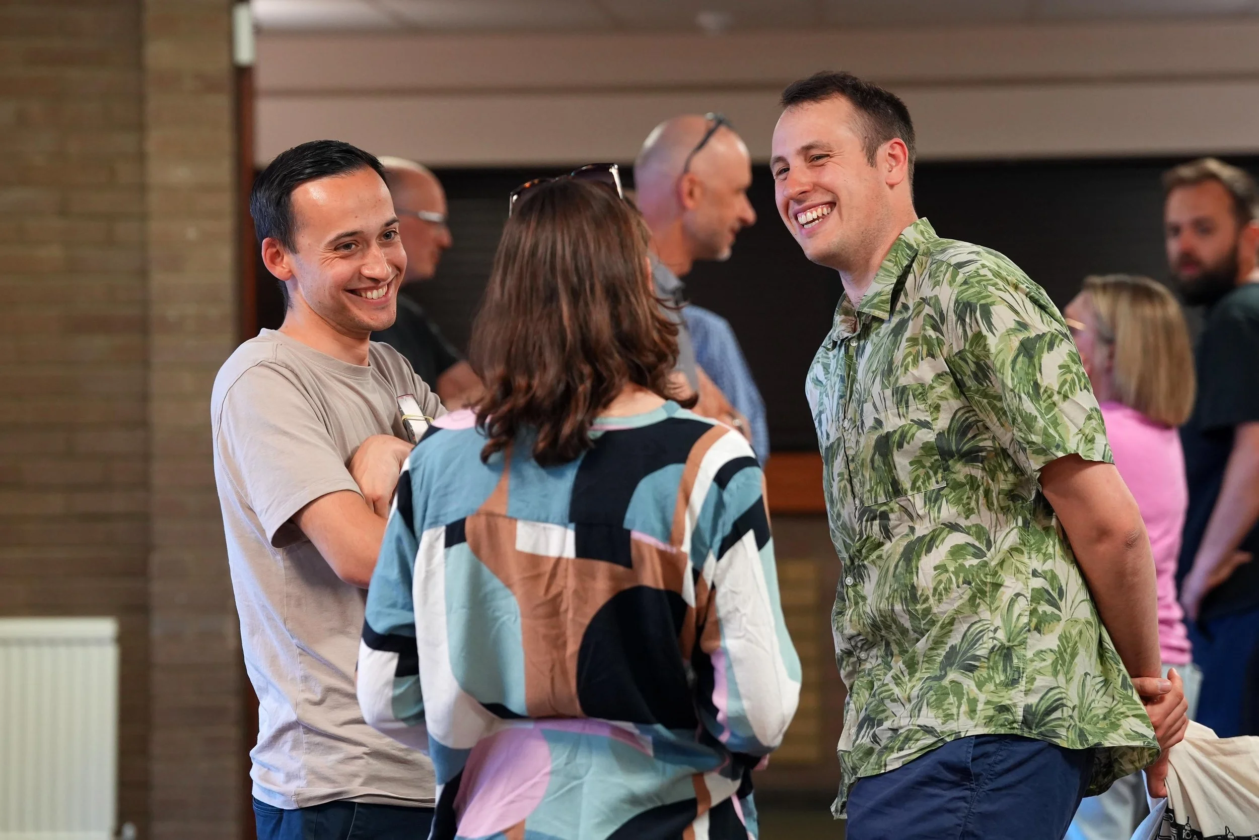 Two men and two women smiling and talking together after a Sunday Service at Grace