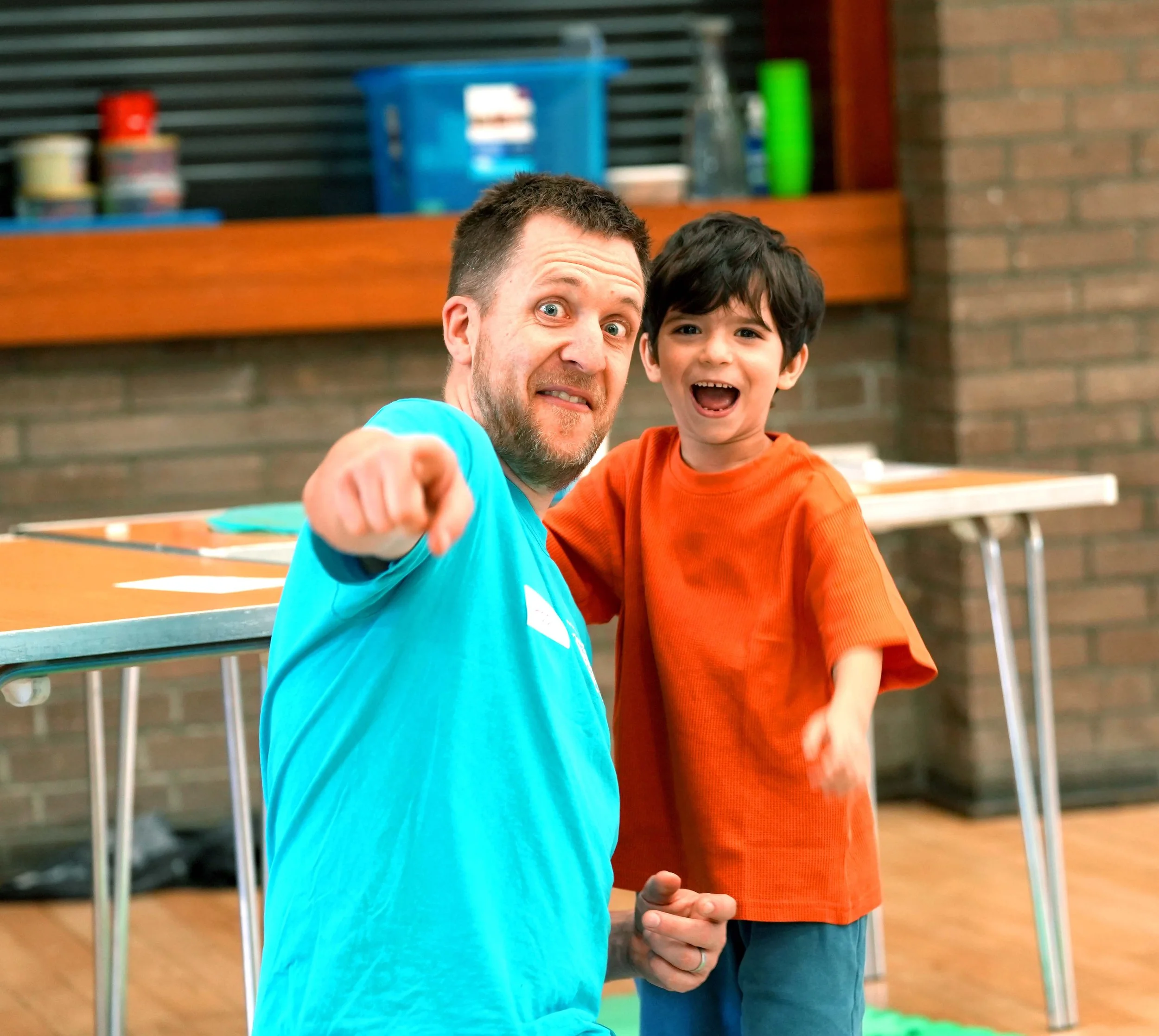 Man and young boy indoors, smiling at camera at a Kids Club run by Grace Community Church in Kempston.