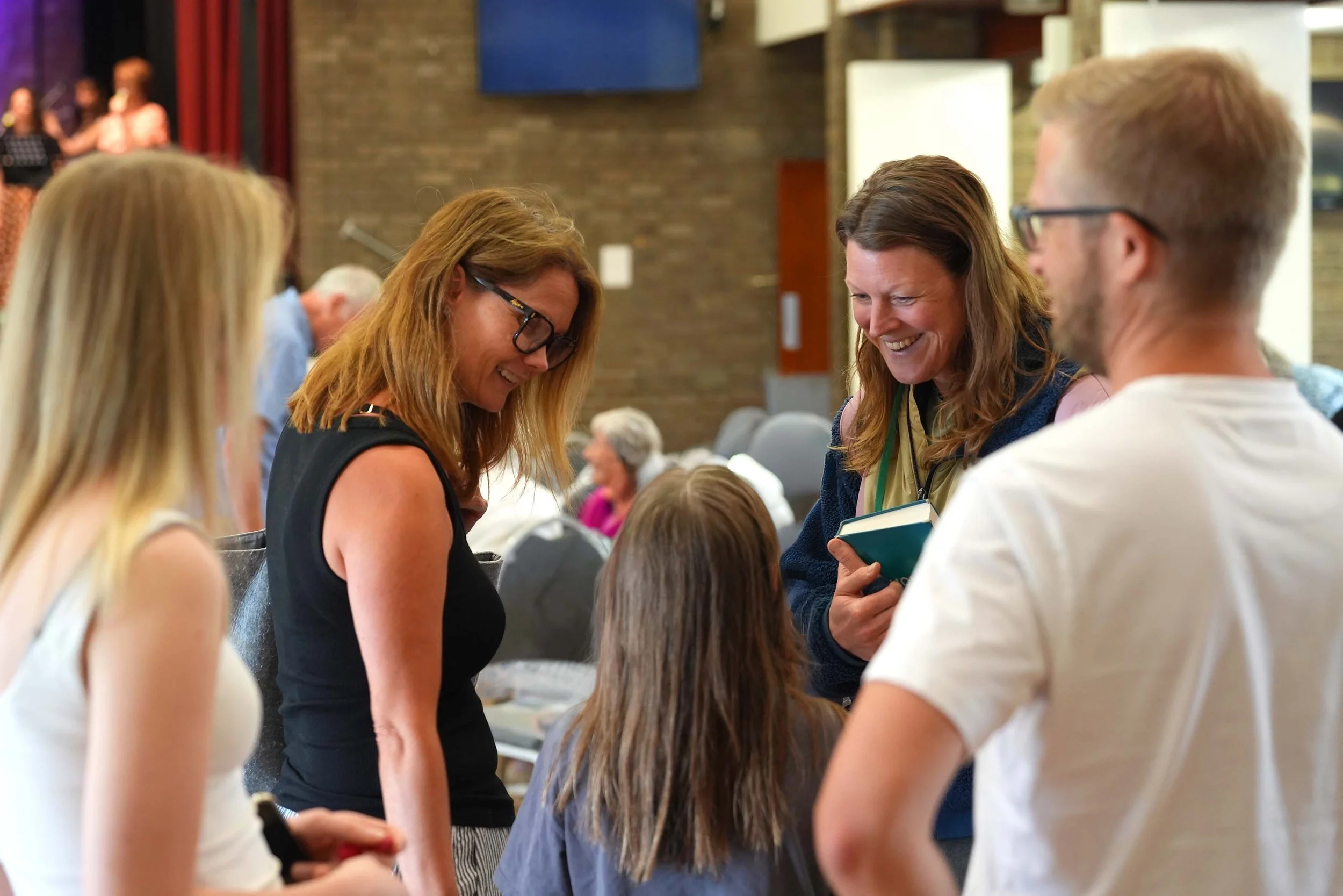 Smiling women engaging in conversation with a younger child at one of our Sunday Services. #Grace #Church #SundayServices