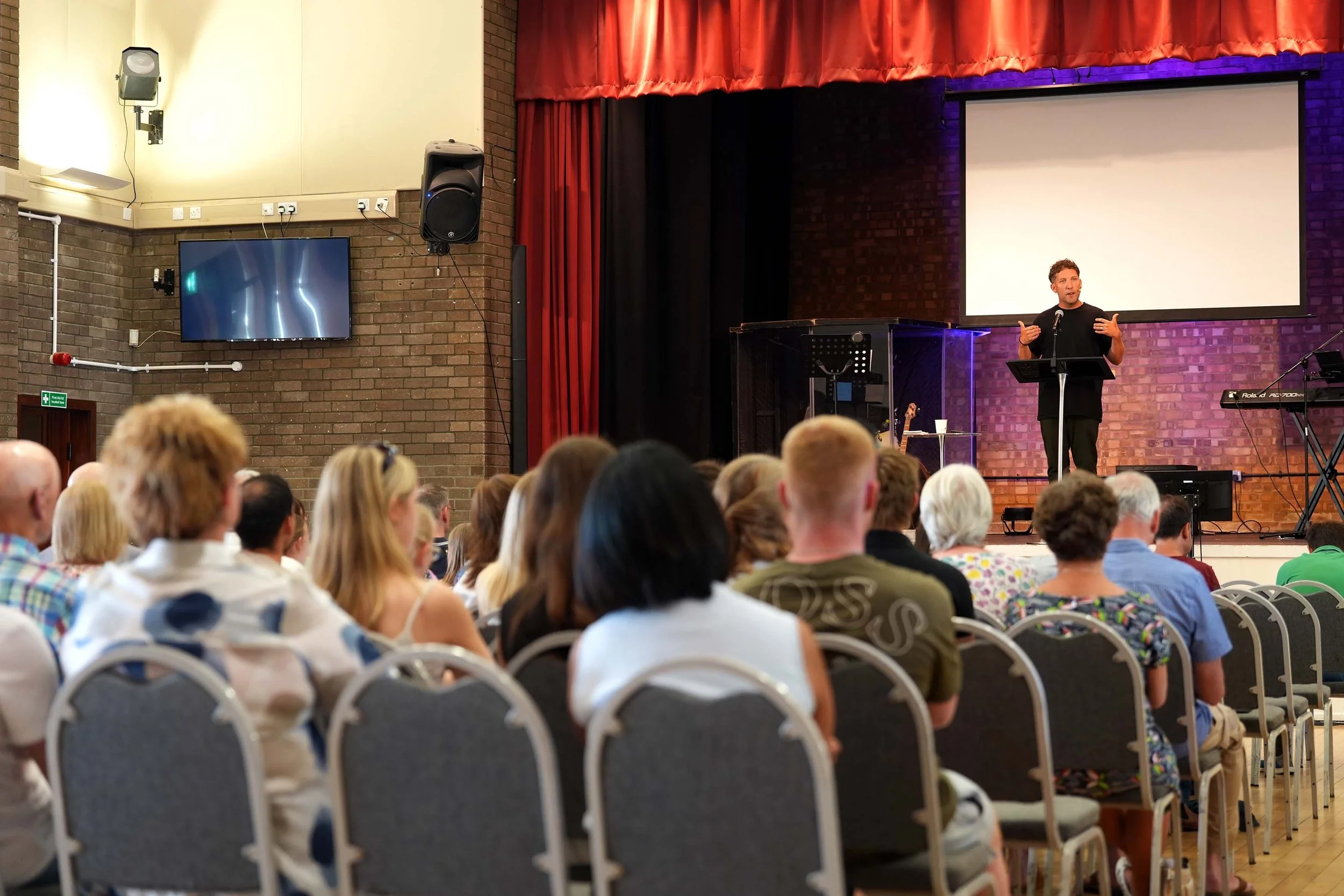 A welcoming service on a Sunday at Grace showing a service leader and congregation. #Church #Community #Grace