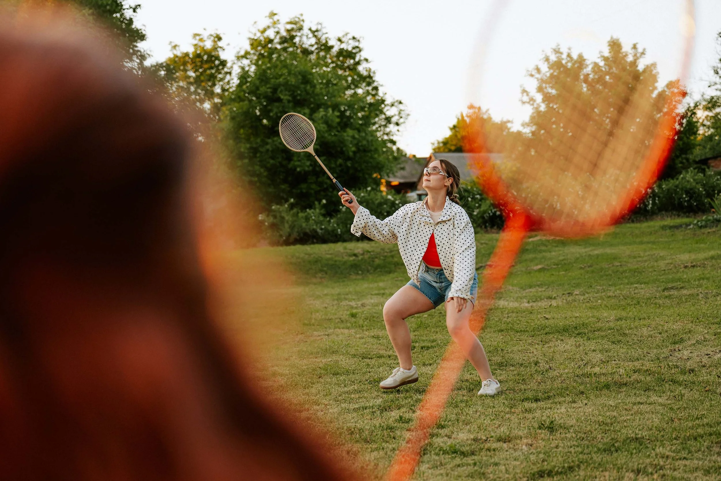 A teenage girl plays badminton at a youth club.