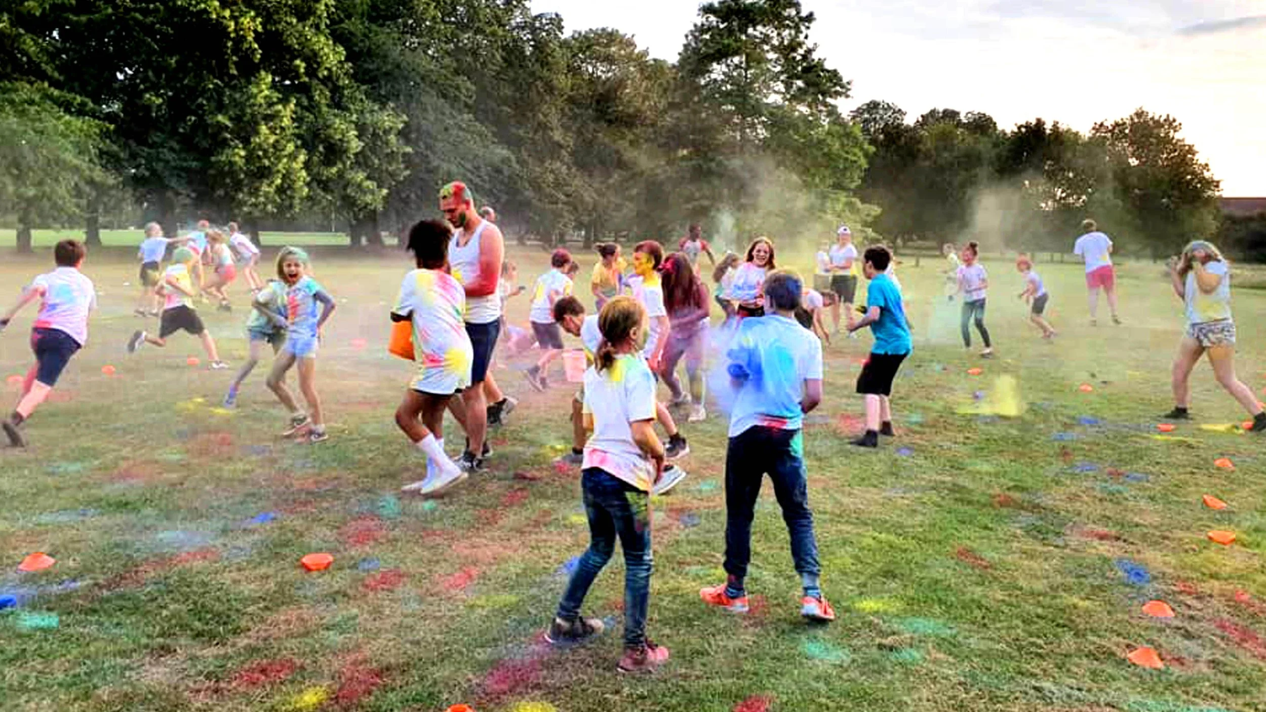 People, mostly children, participating in a color run event in a park during one of the Youth clubs that run at Grace.