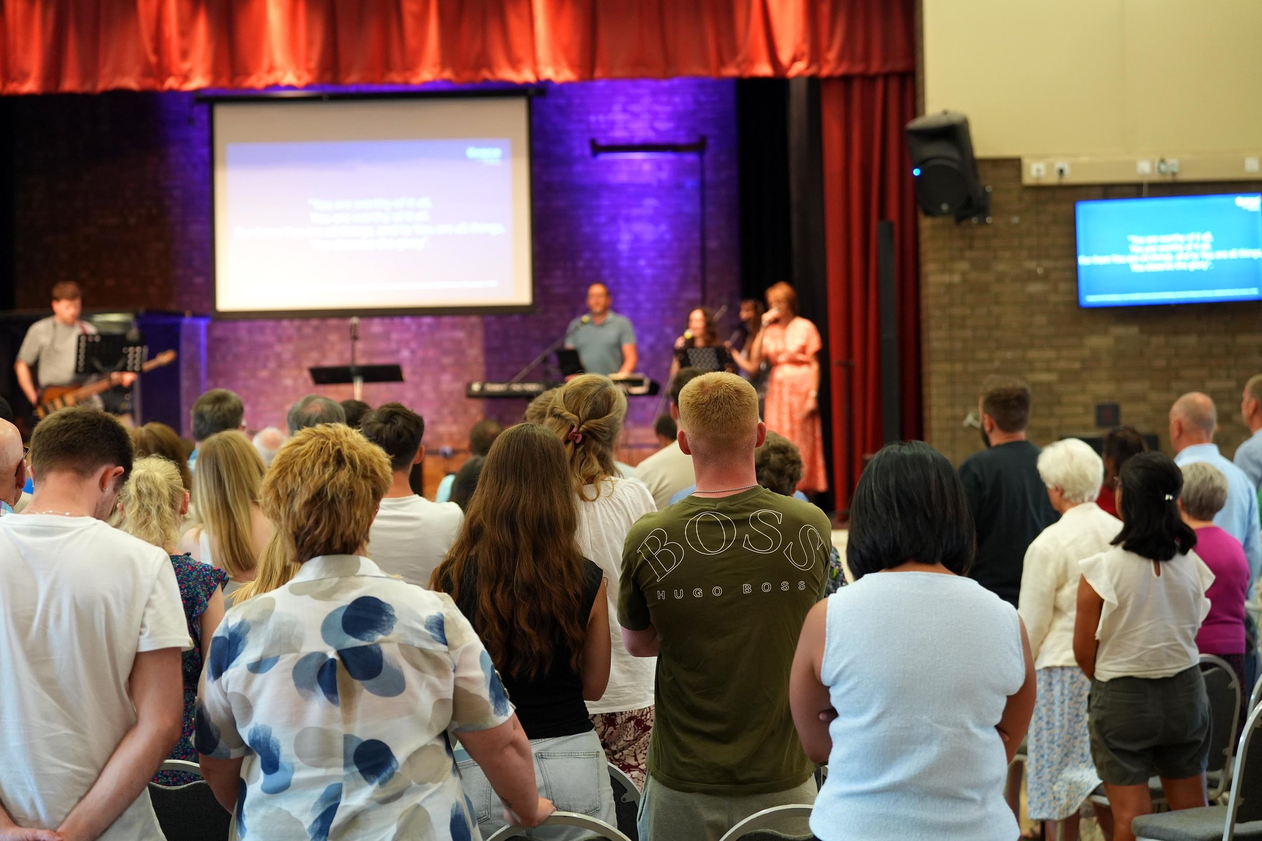 A diverse congregation sings in worship as the band lead - at one of Grace Community Churches Sunday Services. Not been before, give them a try - all are welcome!