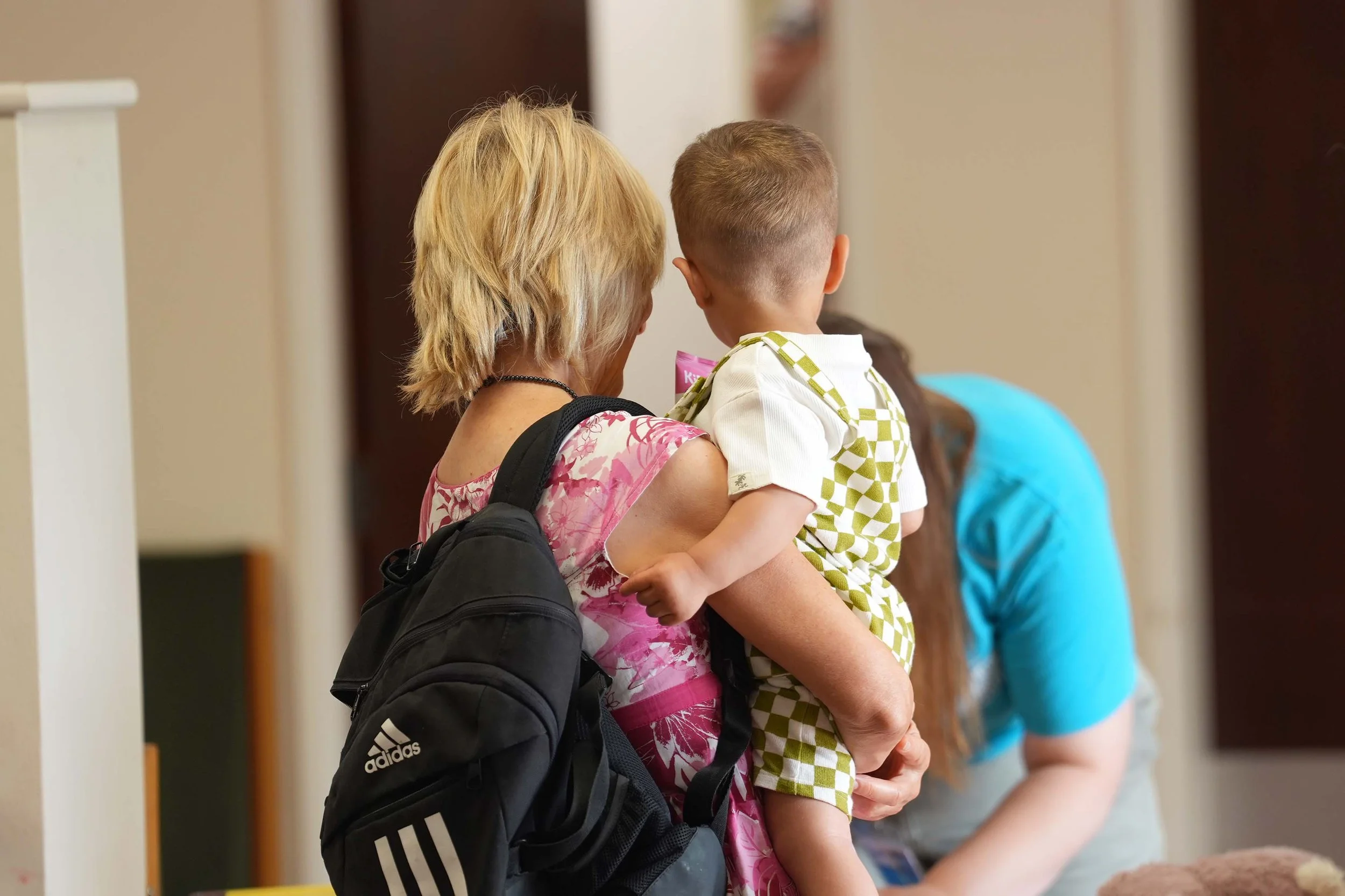 A women taking a young boy into one of the Kids groups that run during the morning services at Grace Community Church.