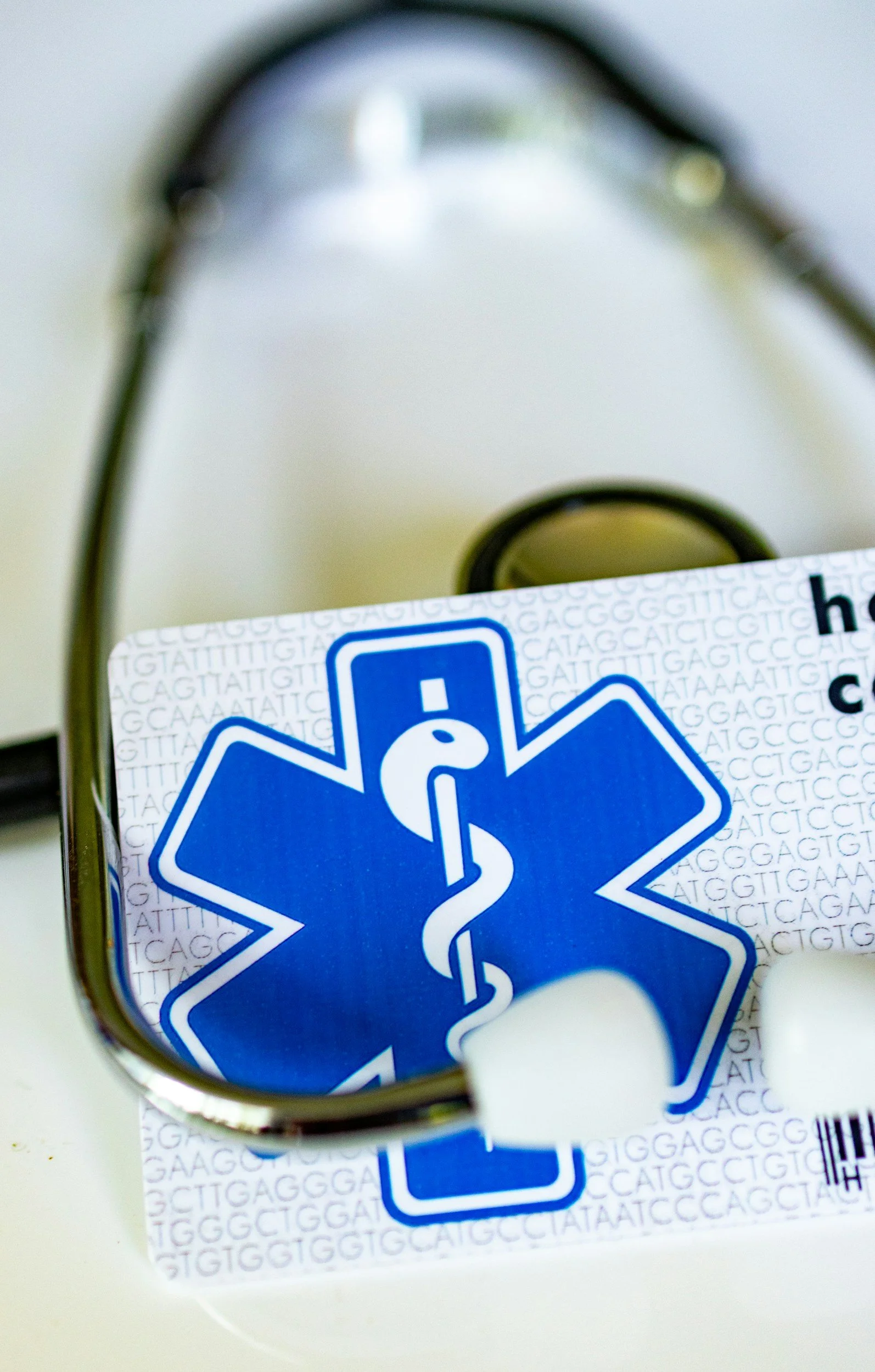 A stethoscope and a box of dna test strips with a Blue and white medical caduceus symbol on it.
