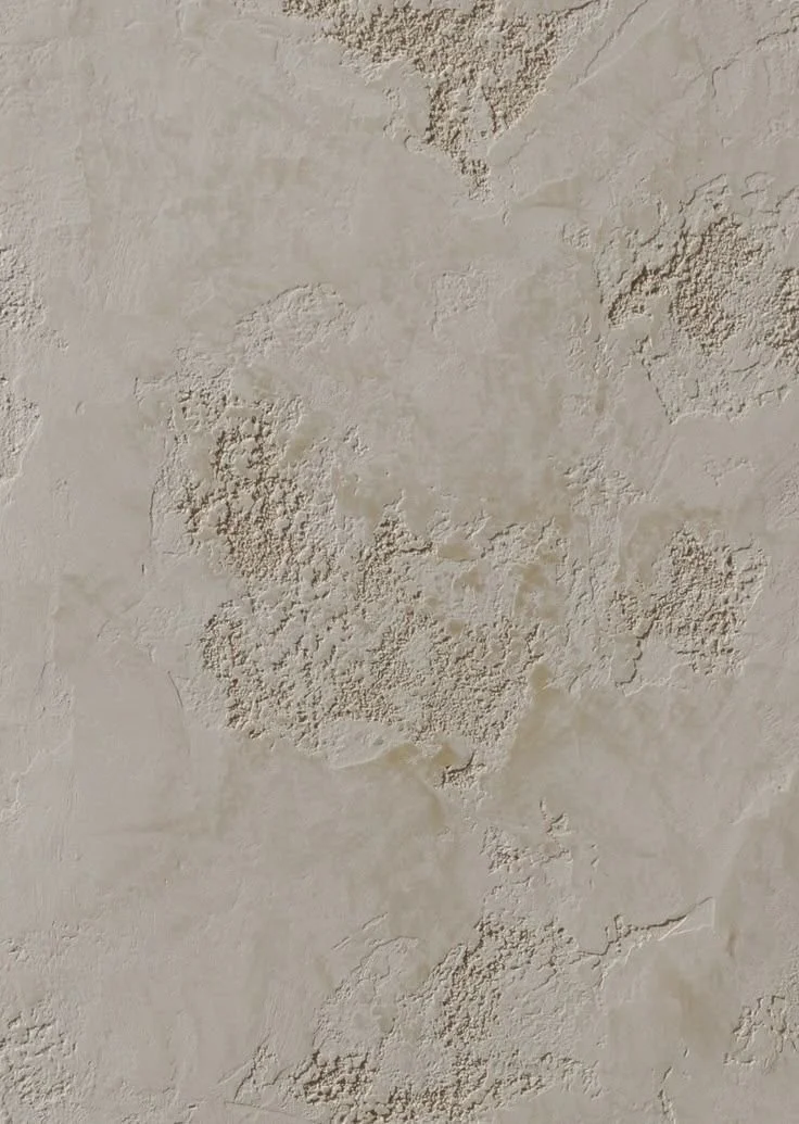 Superficie di parete con finitura accecante in cemento o intonaco in tonalità beige chiara, con texture ruvida e dettagli di screziature