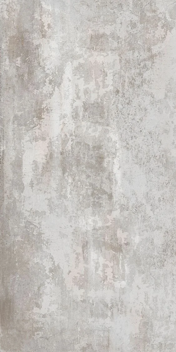 Superficie di parete con finitura in calcestruzzo o intonaco decorativo, color avorio o beige chiaro, con texture ruvida e segni di usura.