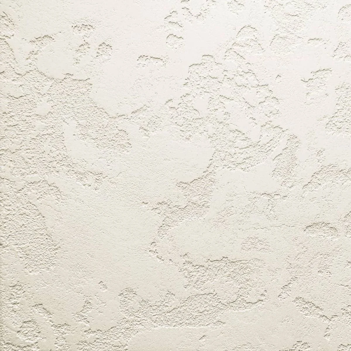 Superficie di un muro con finitura texturizzata e stuccata, di colore chiaro