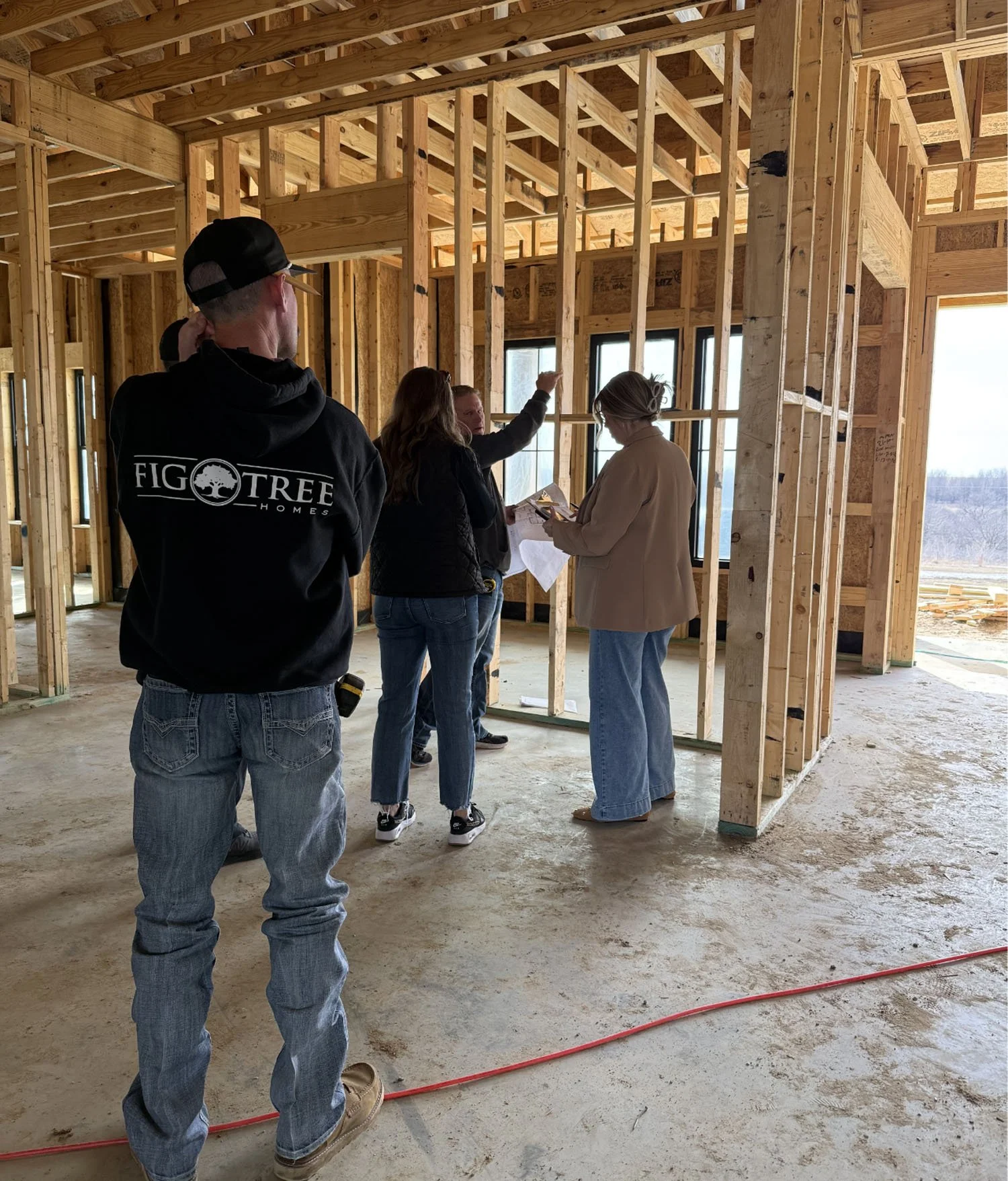 Construction site visit and blueprint review with the Fig Tree Homes team with clients