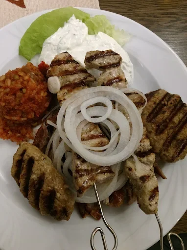 Grillspieße mit Hackfleisch, Zwiebeln, Tomatenreis, Joghurtsoße, Salat und Zitronenscheiben