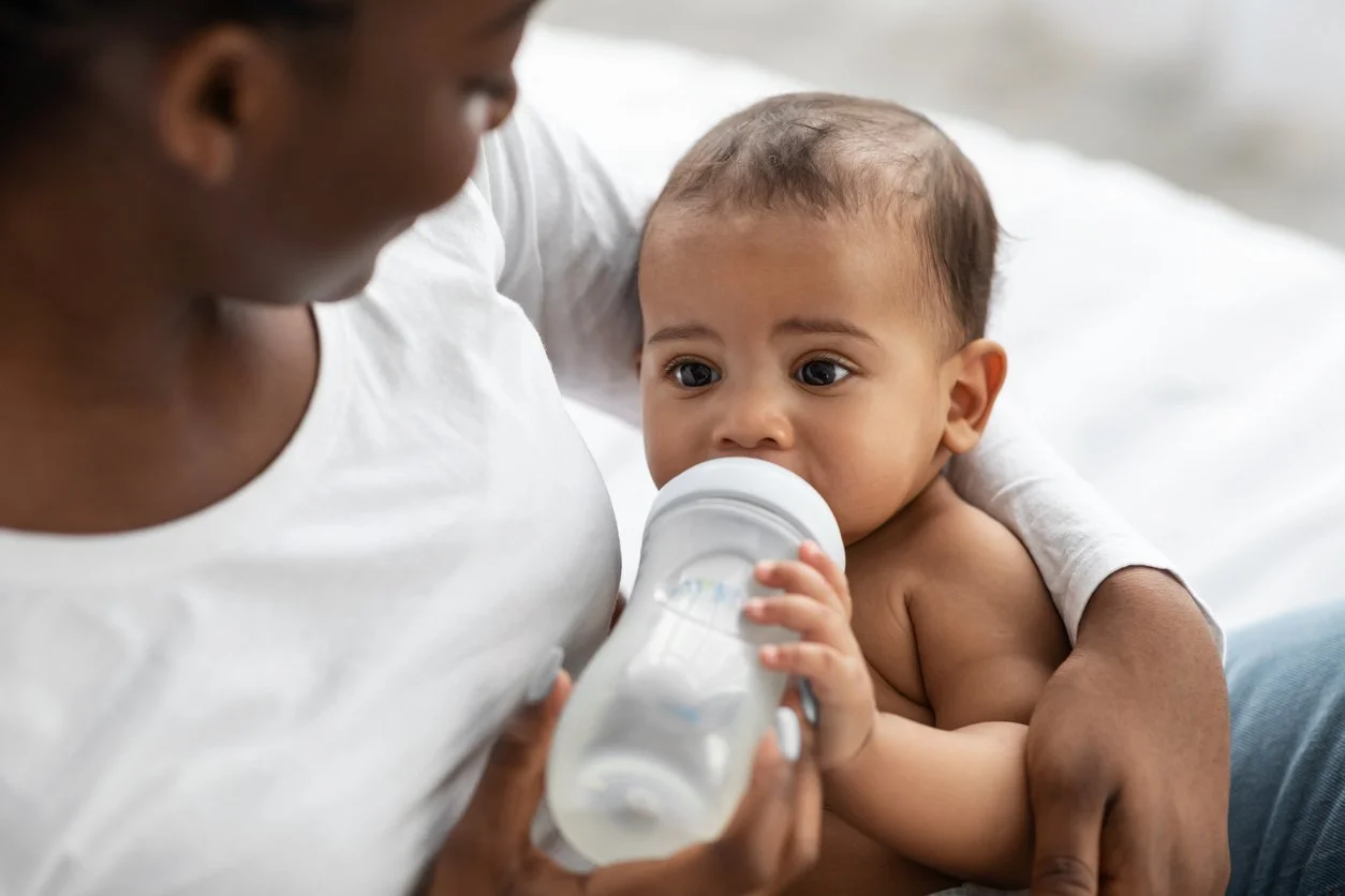 A new mom receiving help with bottle feeding her infant during feeding therapy for kids in Knoxville, TN