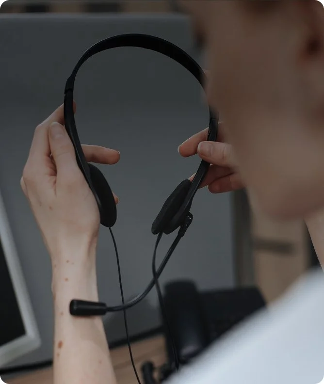 Person holding a headset in front of their face.