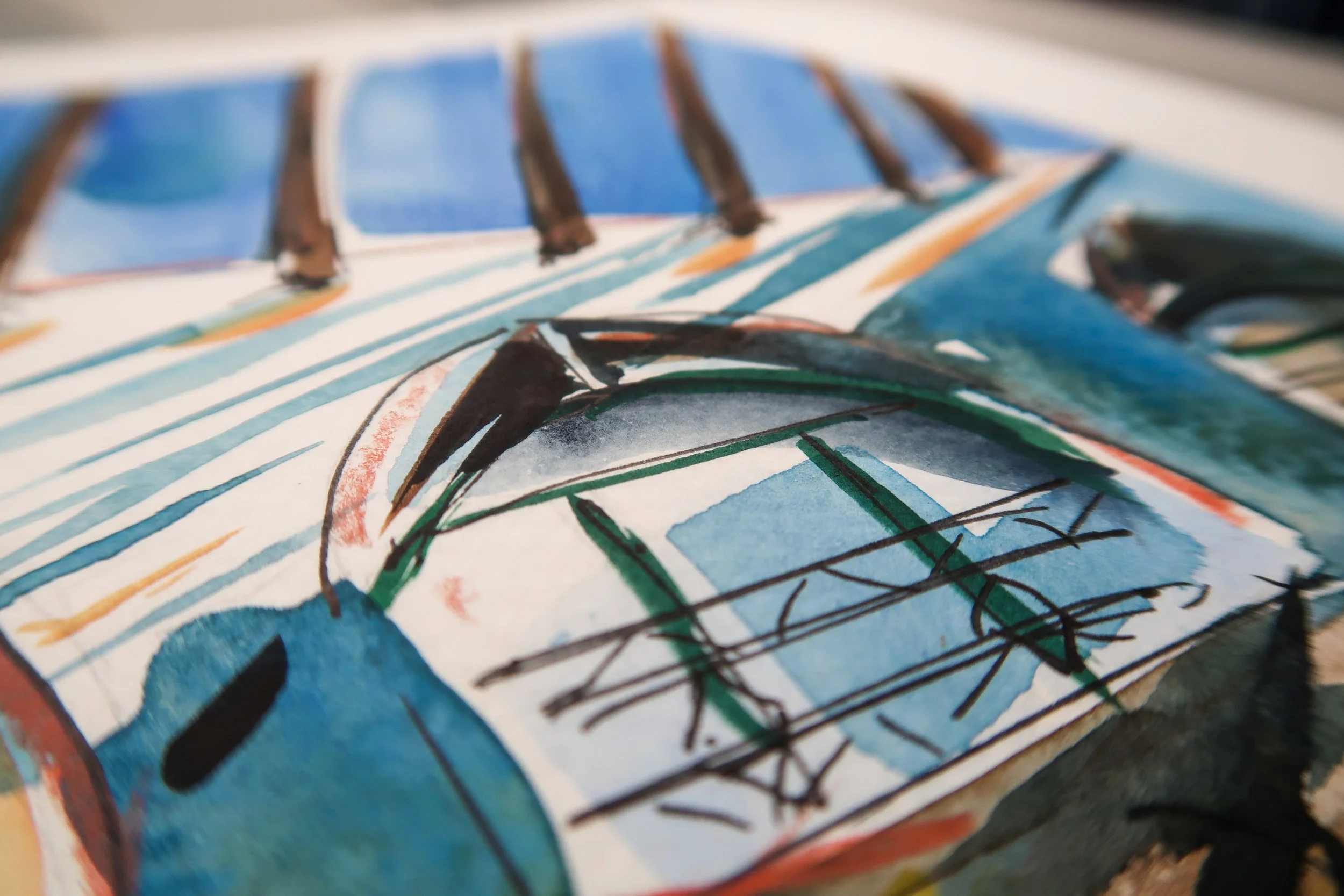 Close-up of a colorful, abstract watercolor painting featuring shades of blue, green, black, and red, with black ink lines creating shapes and patterns.