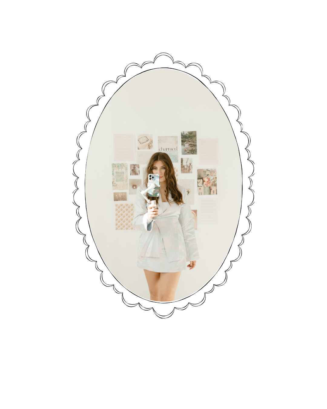 Young woman taking a mirror selfie with a phone, standing in front of a white wall decorated with pictures and art.