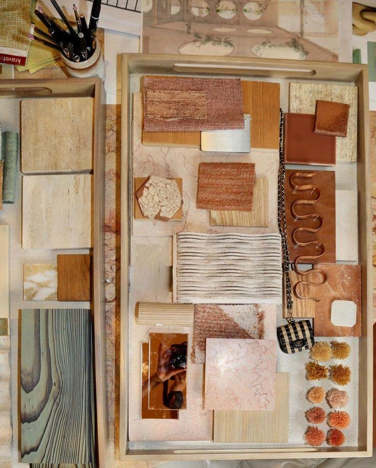A collection of design materials including tiles, fabric swatches, a chain, and small decorative objects arranged in containers for interior decorating.