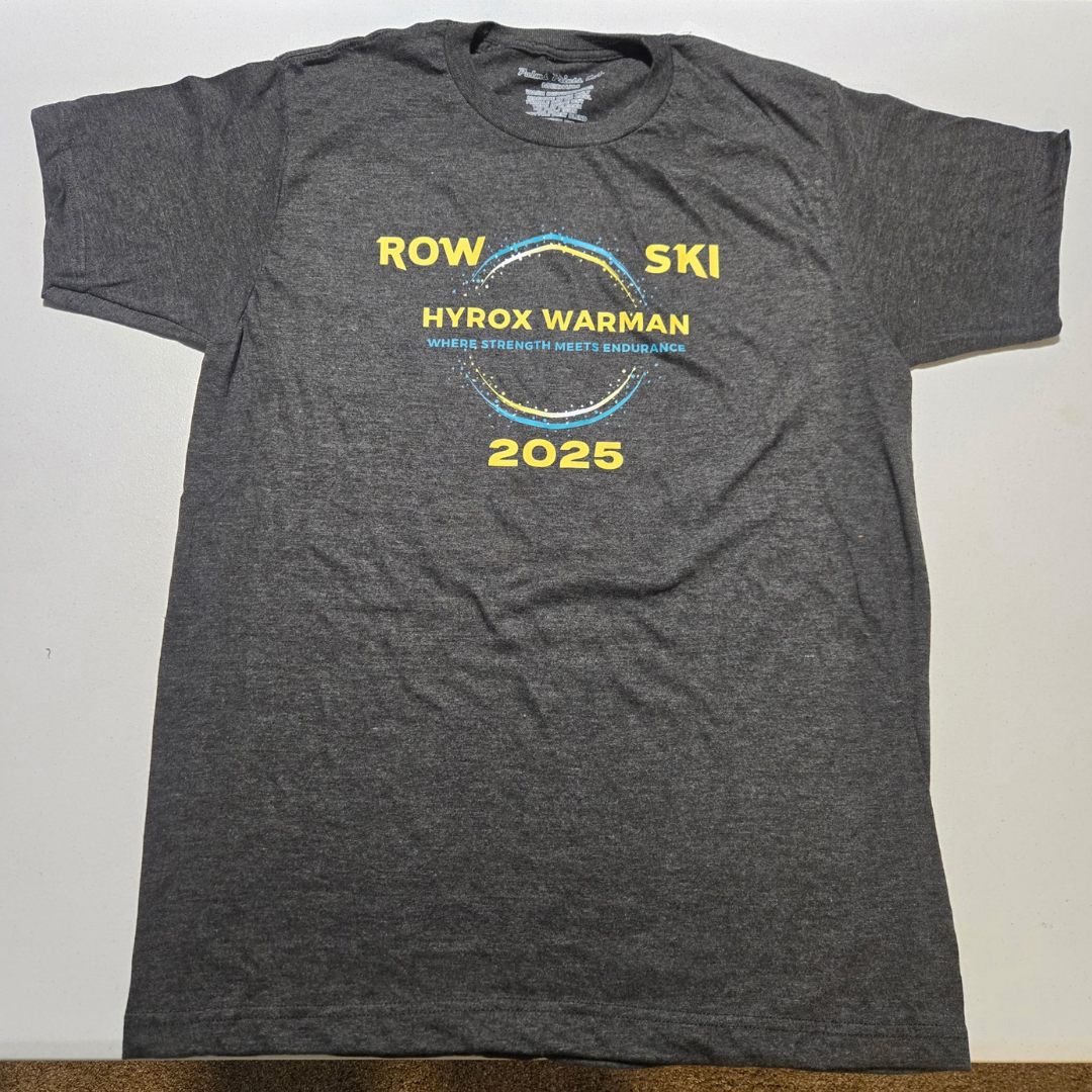 Gray t-shirt with yellow and blue text and graphics promoting the 2025 Row Ski Hyrox Warman event, with the slogan 'Where Strength Meets Endurance'.
