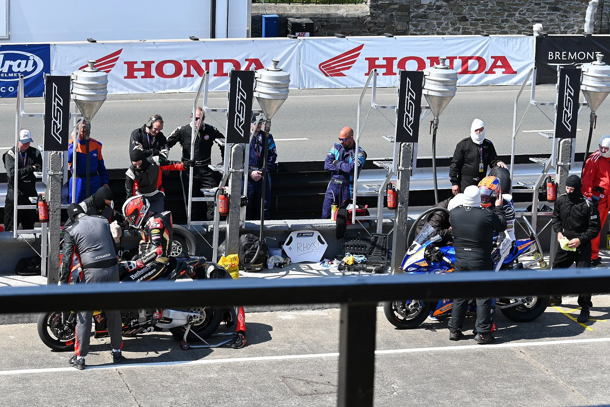 #12 Michael Rutter - 1000 Honda - Banthams Ales racing (l) and #14 Philip Crowe - 1000 BMW - Nigel Appleyard/Agri Wash racing (r) both pit during the RST Superbike TT Race.  Typically riders will take on Gas, a new rear tyre, hydration and helmet fac
