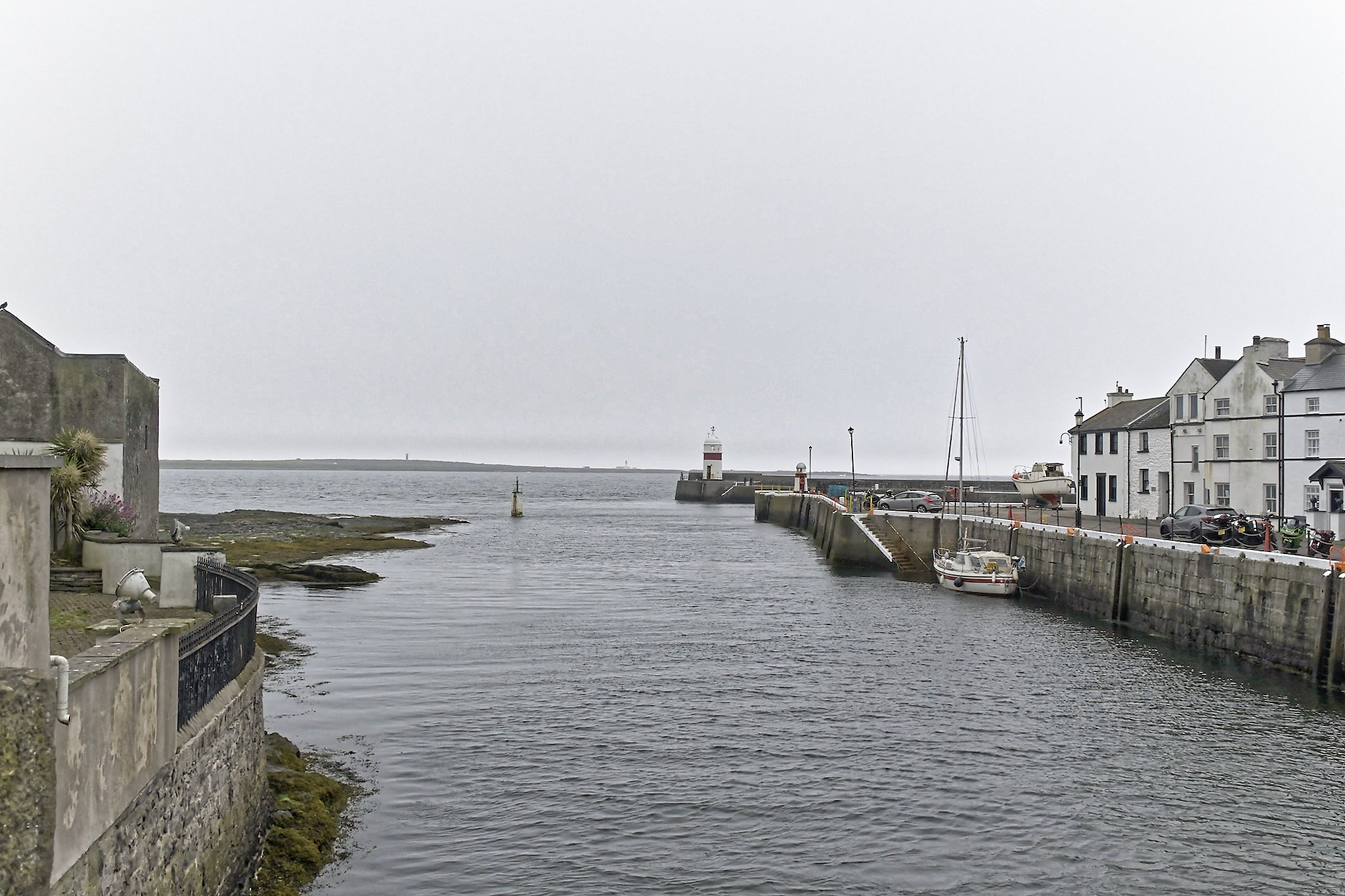 Looking seaward from the entrance of the harbor, with Castletown Lighthouse at the end of the breakwater. 