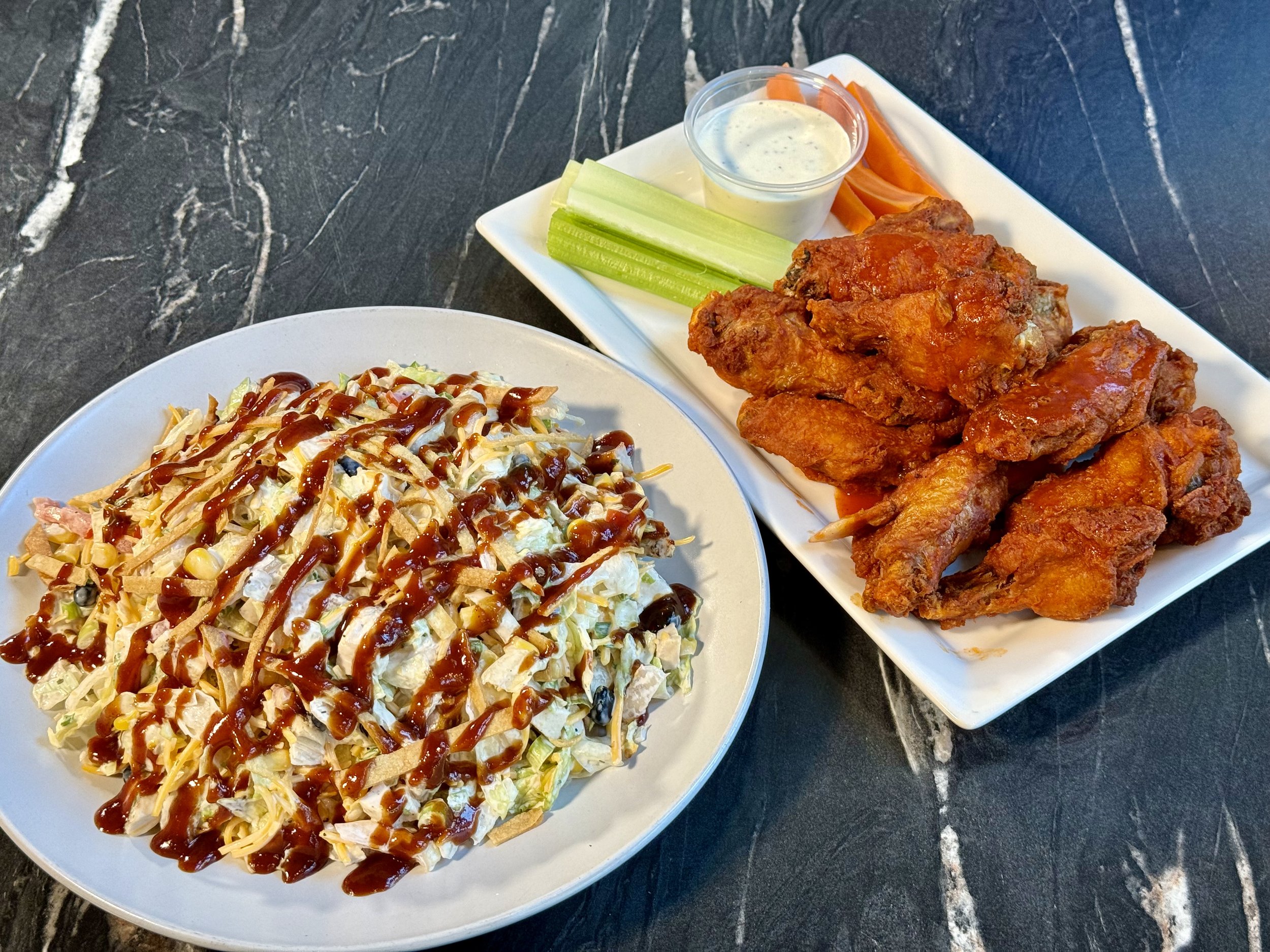 BBQ Chicken Chopped Salad with Chicken Wings
Shredded lettuce, chicken, tomatoes, black beans, corn, green onions & cheddar cheese tossed in ranch dressing.
Drizzled with bbq sauce and tortilla strips.