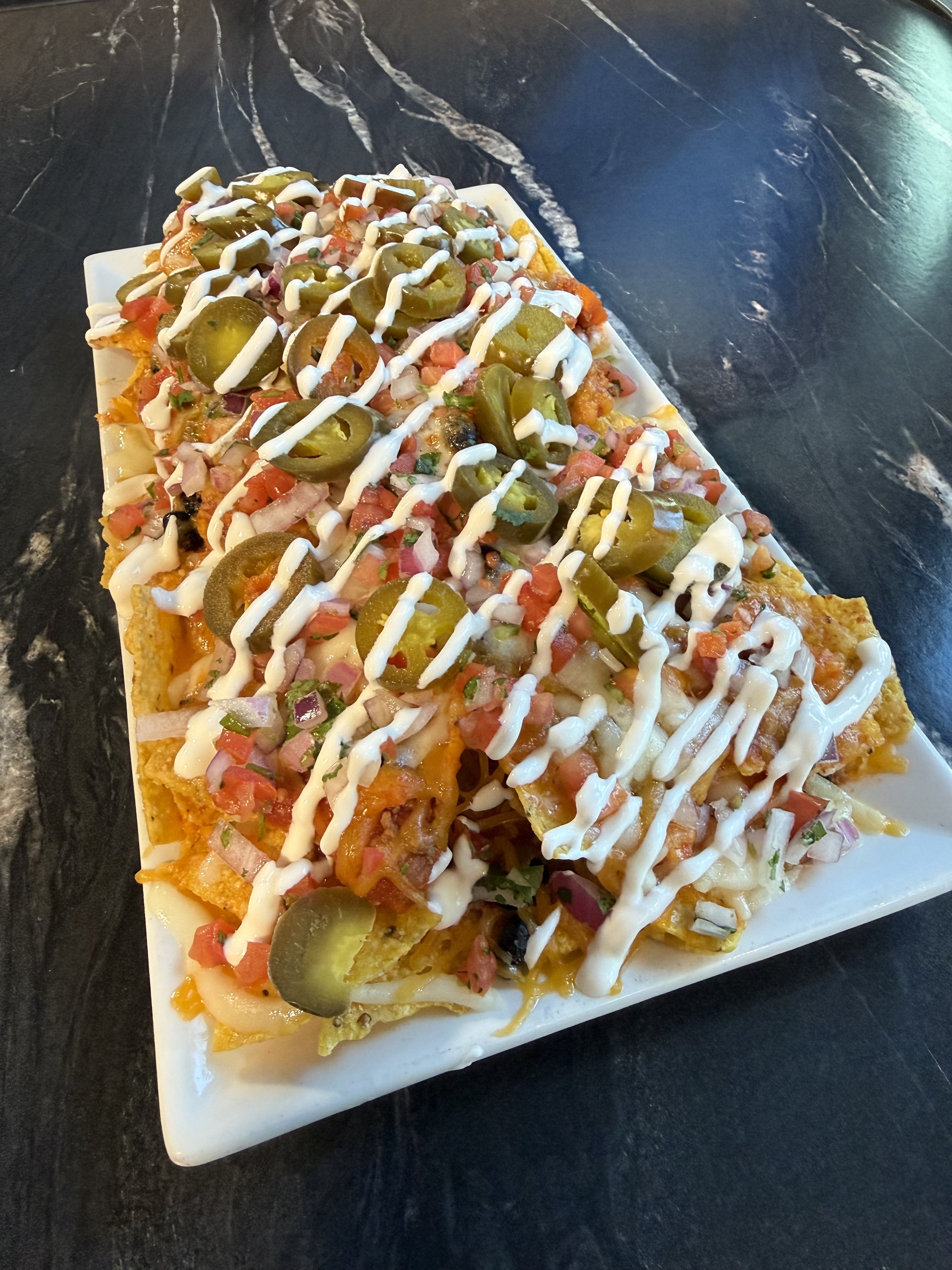 Chili Nachos..
Housemade angus beef chili, cheddar & mozzarella cheese, pickled jalapeños, sour cream, green onions