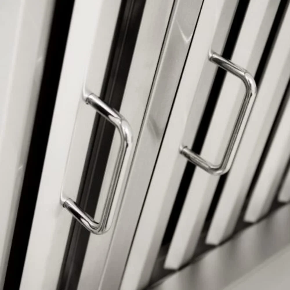 Close-up of metallic handles on a metal cabinet or locker door with black and white vertical stripes.