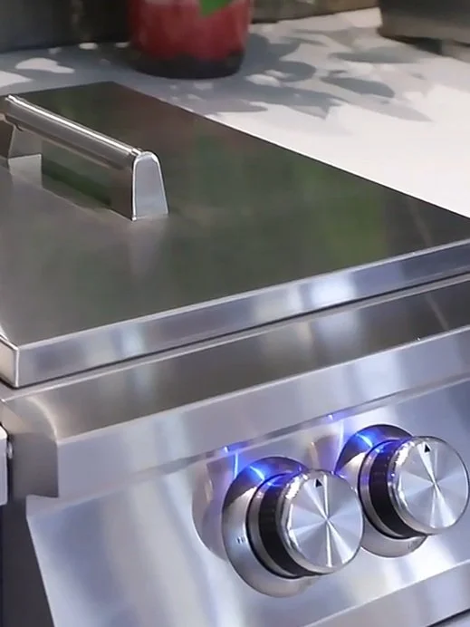 Close-up of stainless steel outdoor gas grill with two control knobs