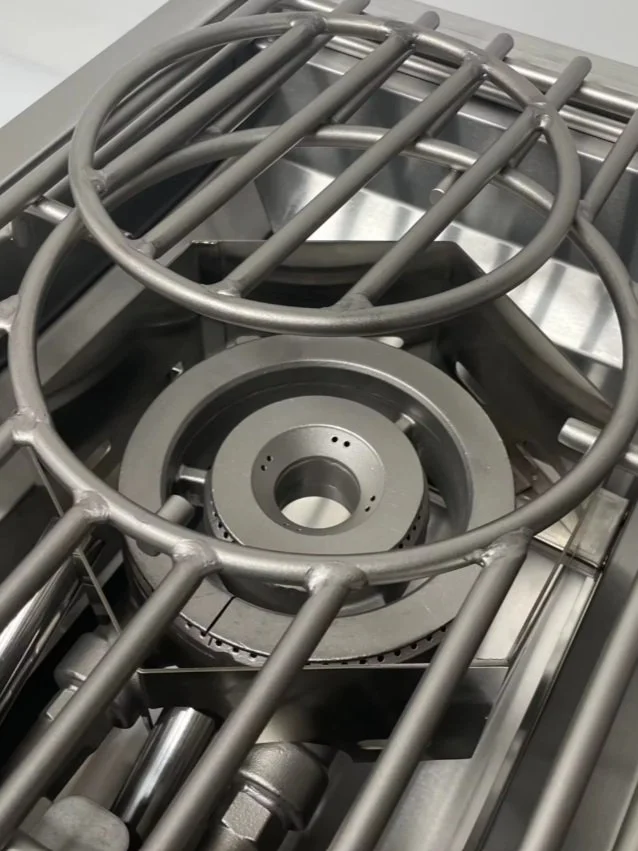 Close-up of metallic industrial machinery parts, including a circular grate and gears.