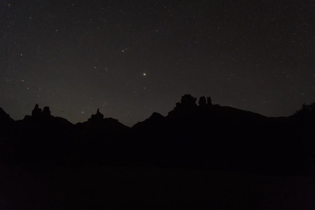 Star-filled night sky above the silhouetted sandstone formations of Charyn Canyon, Kazakhstan